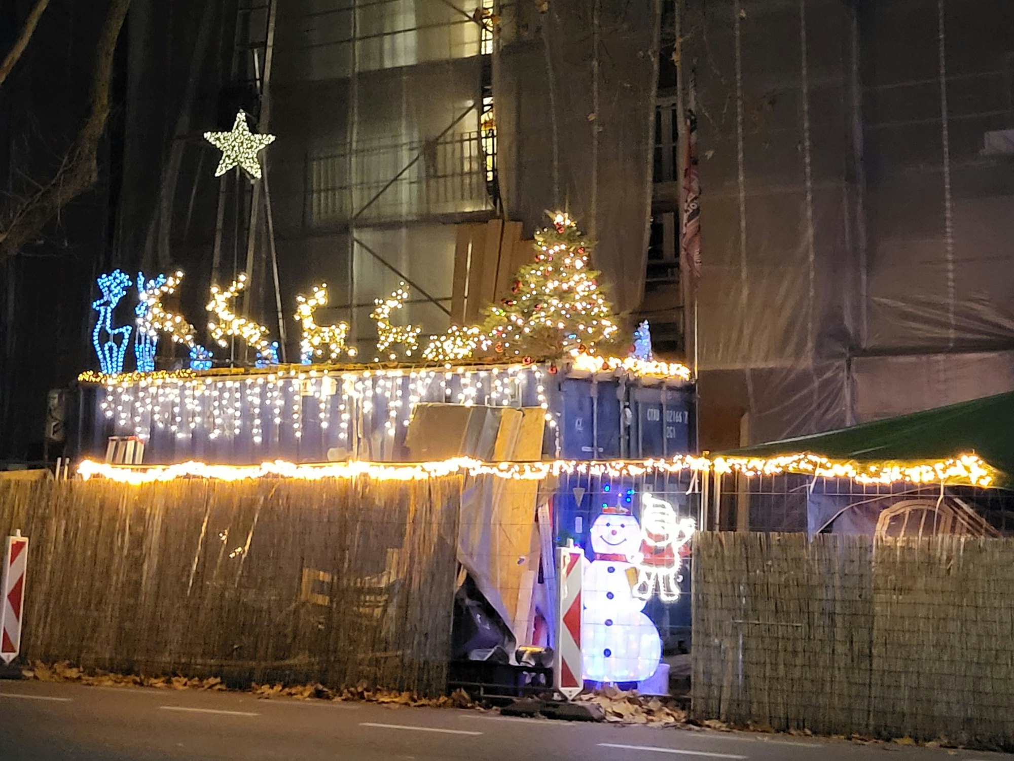 Eine Baustelle ist weihnachtlich geschmückt, mit Lichterketten und Rentieren.