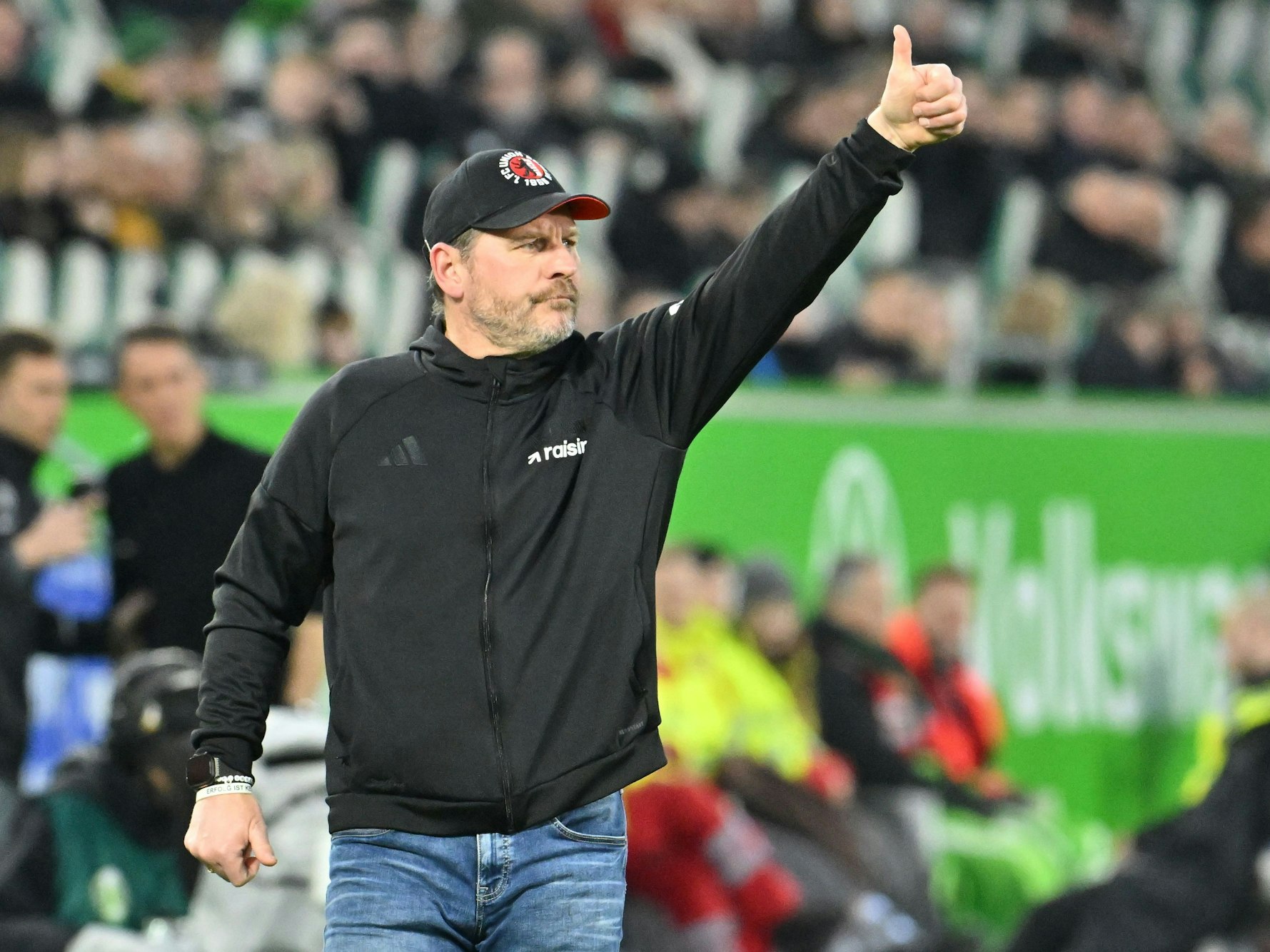 Trainer Steffen Baumgart zeigt an der Seitenlinie einen Daumen nach oben.