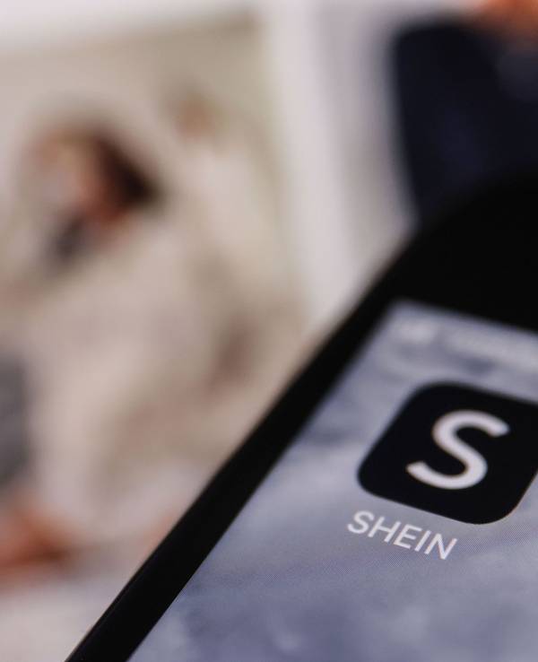 Die Apps der Internethändler Temu und Shein sind auf dem Display eines Smartphones zu sehen.
