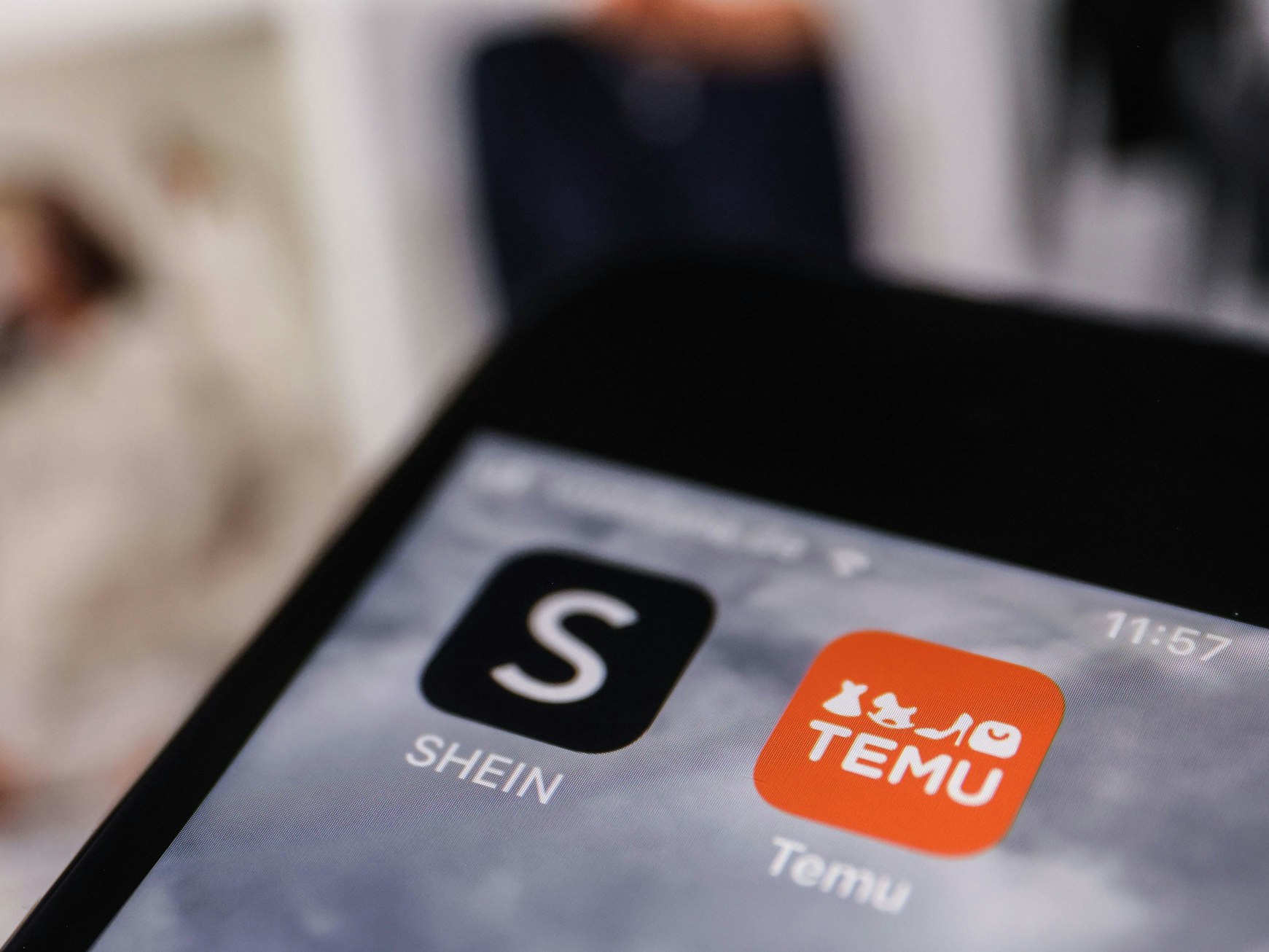 Die Apps der Internethändler Temu und Shein sind auf dem Display eines Smartphones zu sehen.
