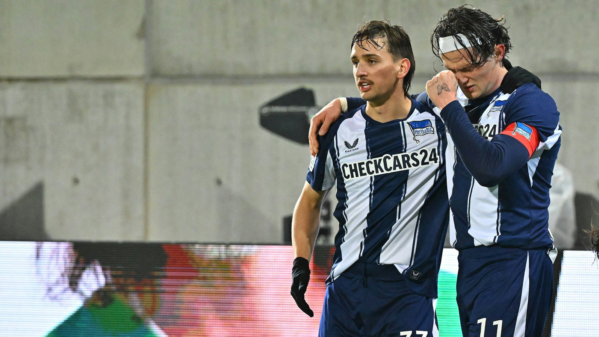 Fabian Reese (l.) und Michal Karbownik stehen Arm in Arm auf dem Spielfeld.
