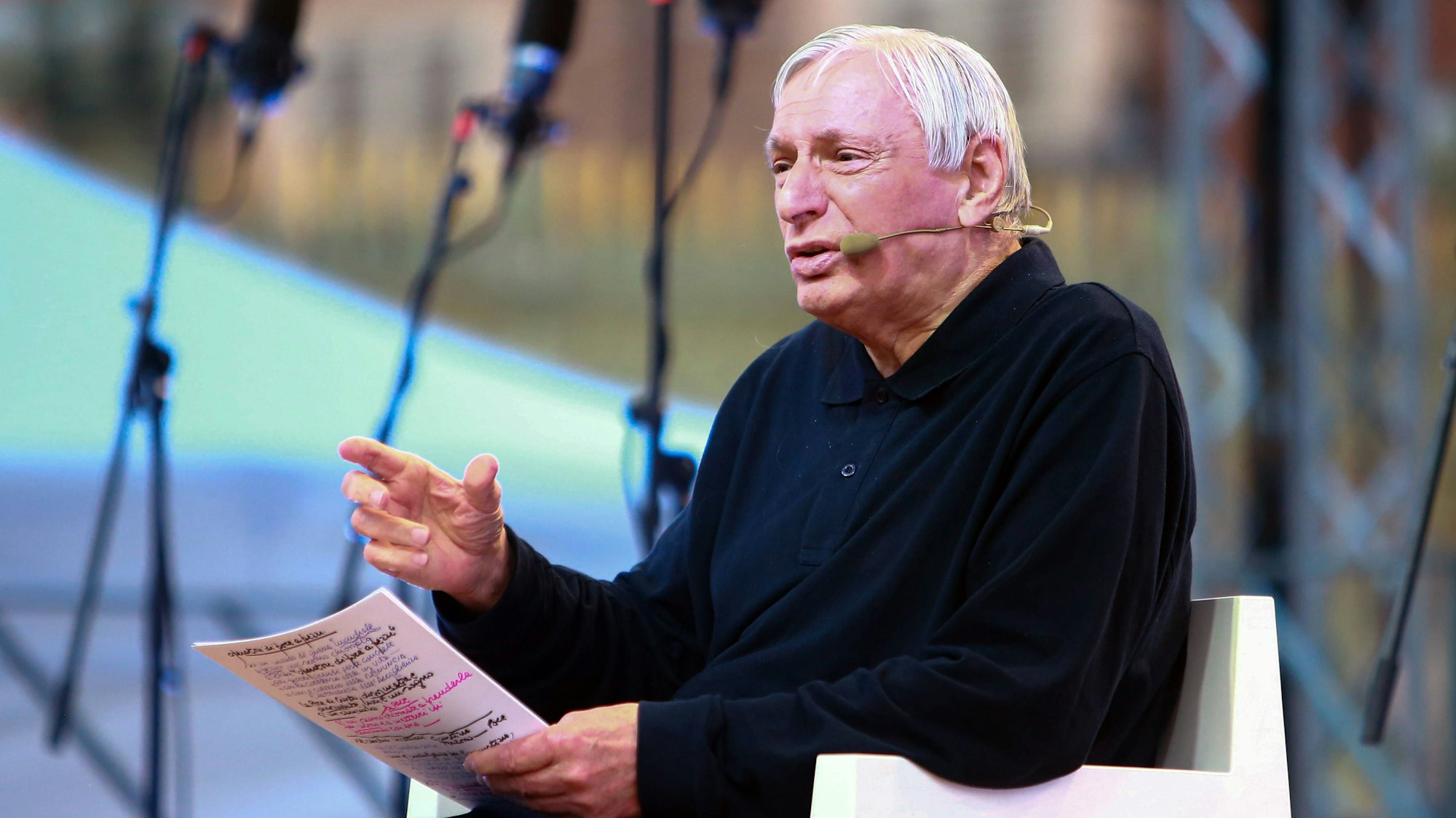 Don Luigi Ciotti spricht und hält Papiere