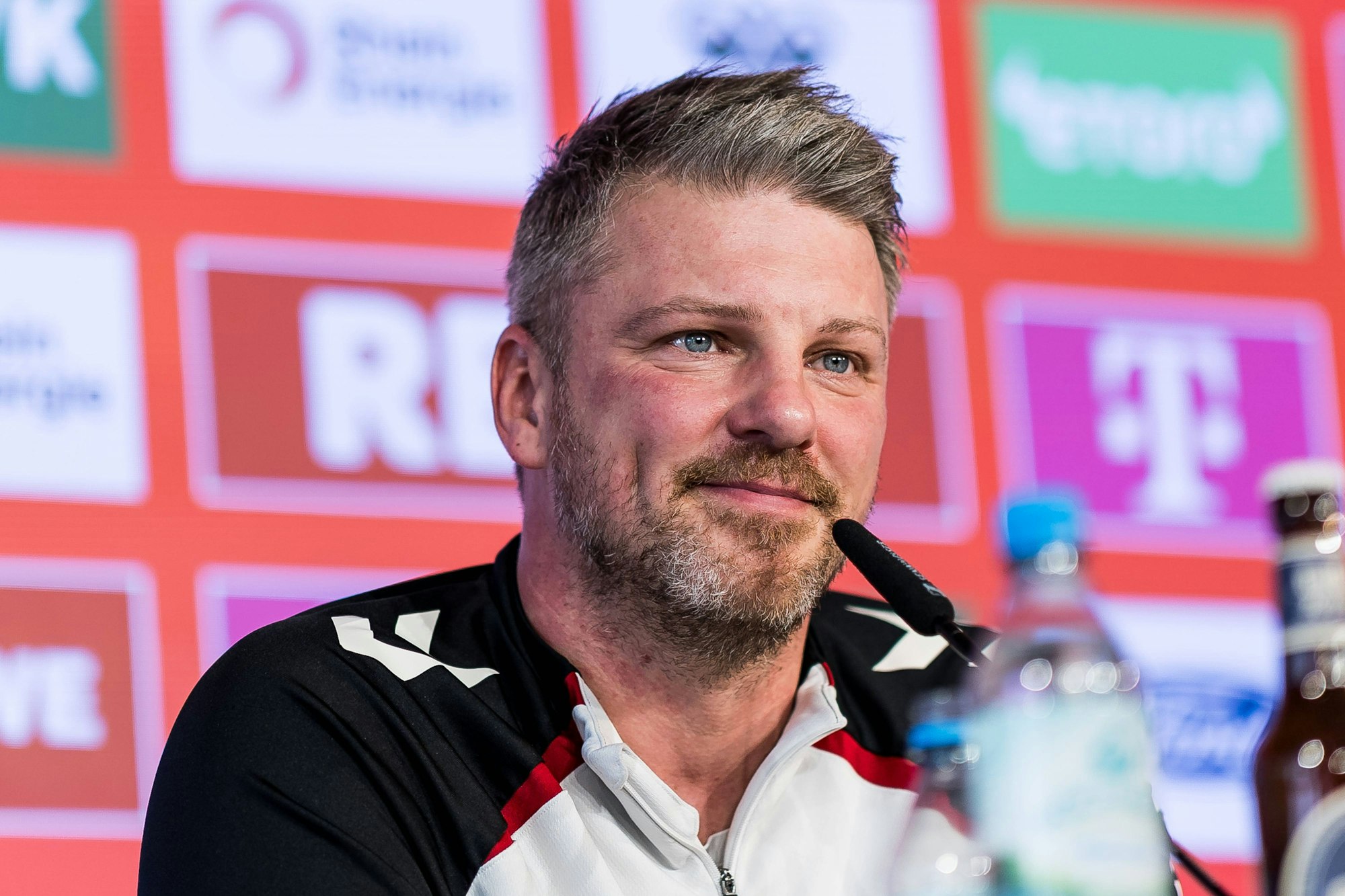 Lukas Kwasniok sitzt bei einer Pressekonferenz vor einem Mikrofon.