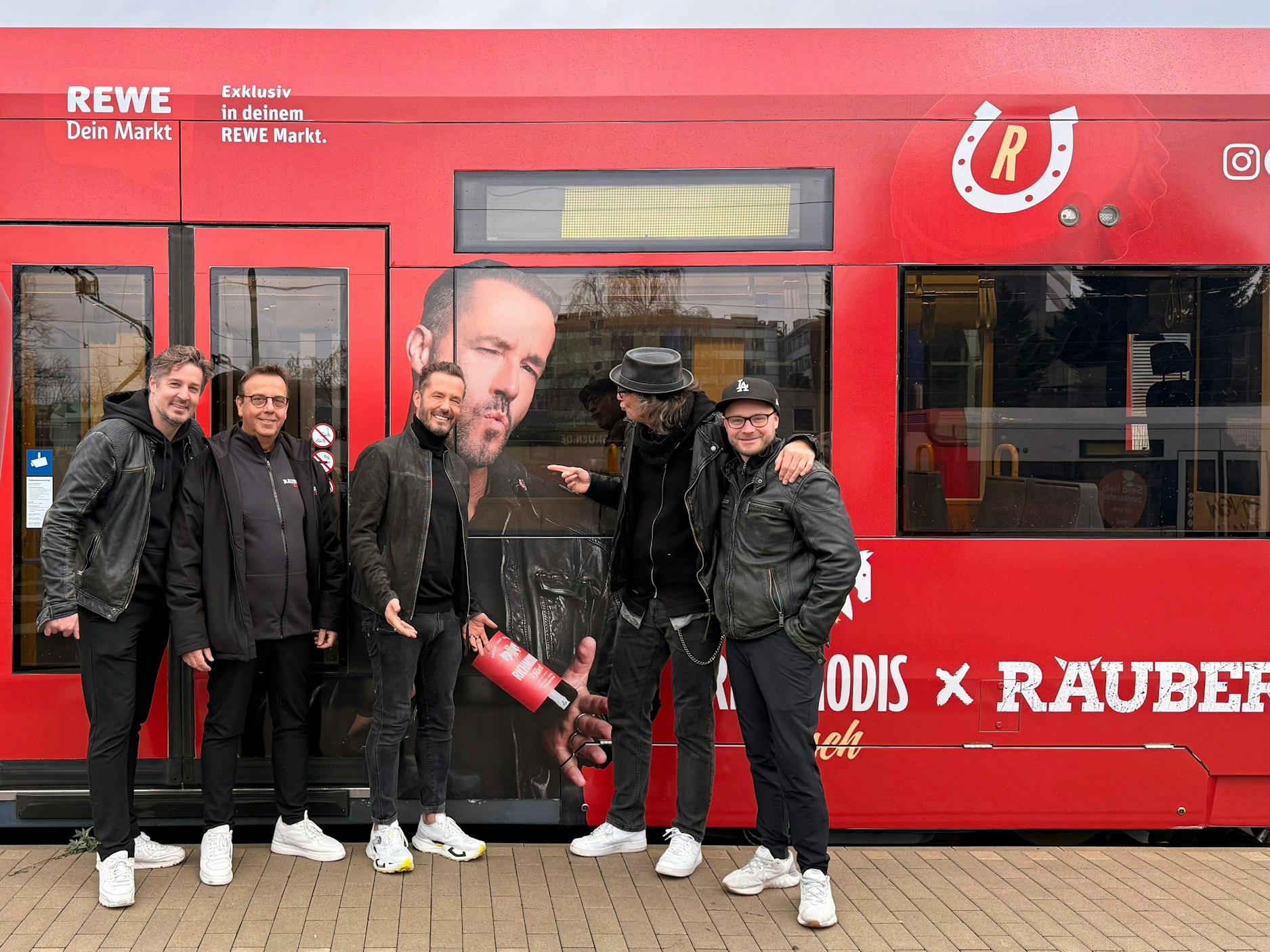 Die Räuber stehen vor ihrer Straßenbahn.