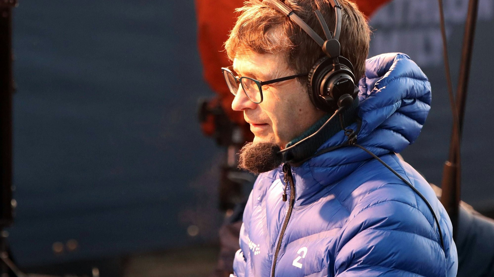 Ole Einar Björndalen in blauer Jacke mit Kopfhörern