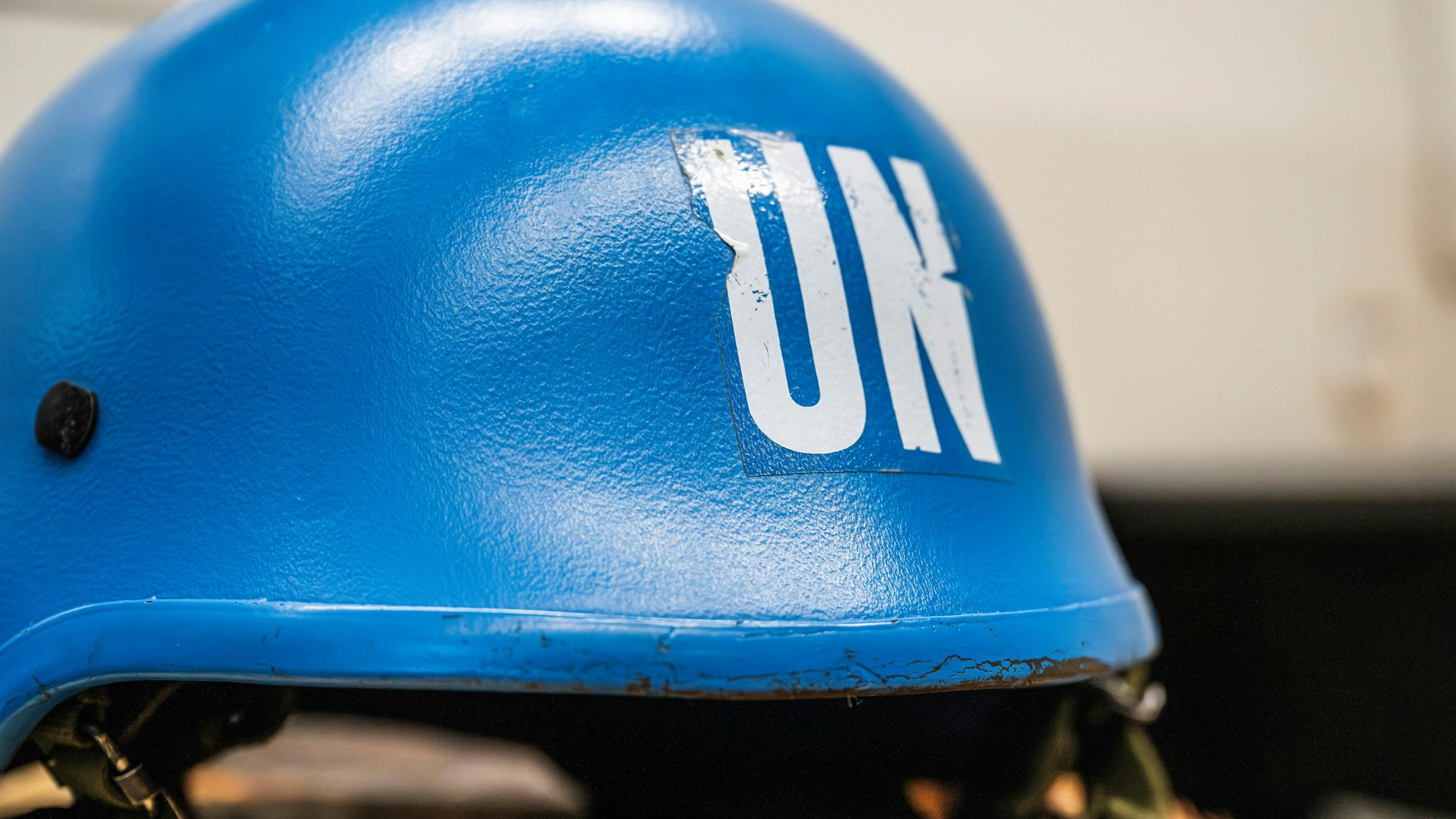 Abgenutzter blauer UN-Helm mit weißem Schriftzug