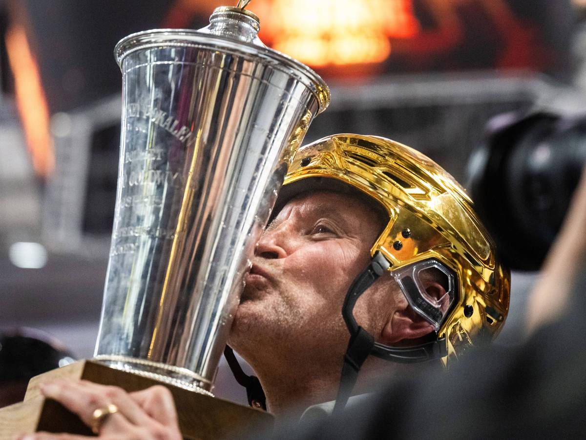 Thomas Berglund küsst mit goldenem Helm den Meisterpokal.