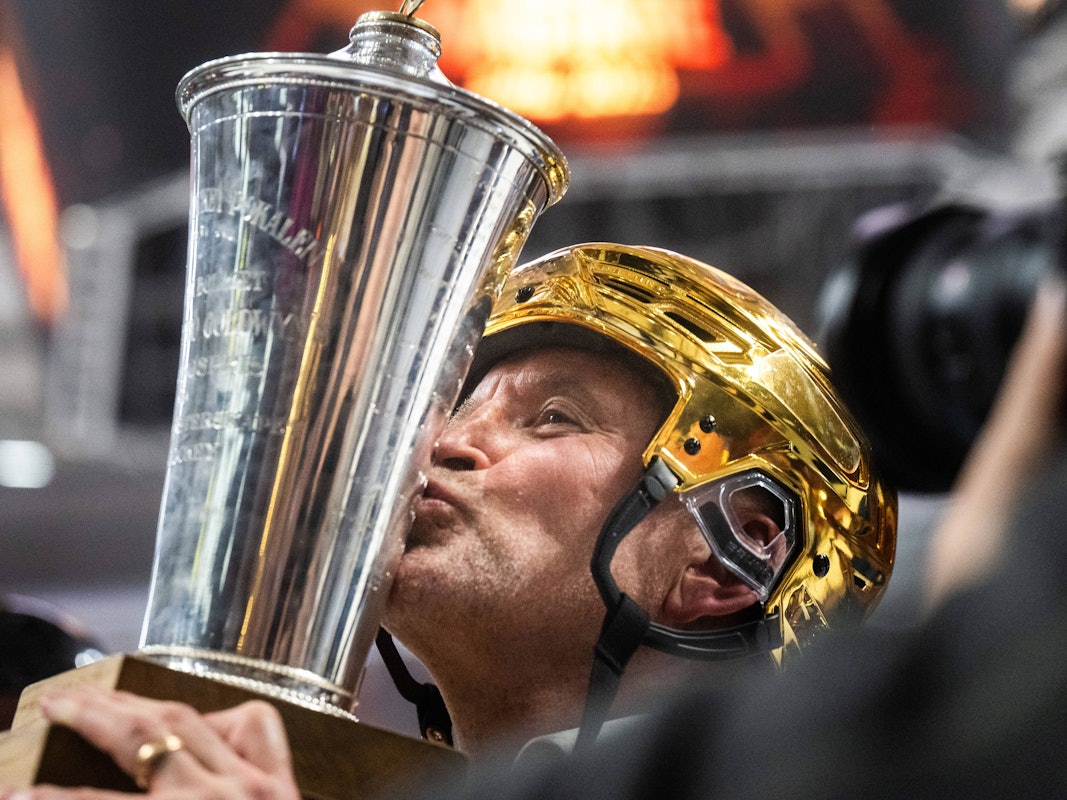 Thomas Berglund küsst mit goldenem Helm den Meisterpokal.