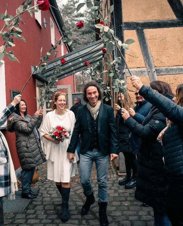 Anja und Stephan Brings gehen nach ihrer Hochzeit durch ein Spalier.
