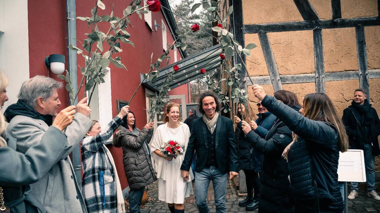 Anja und Stephan Brings gehen nach ihrer Hochzeit durch ein Spalier.