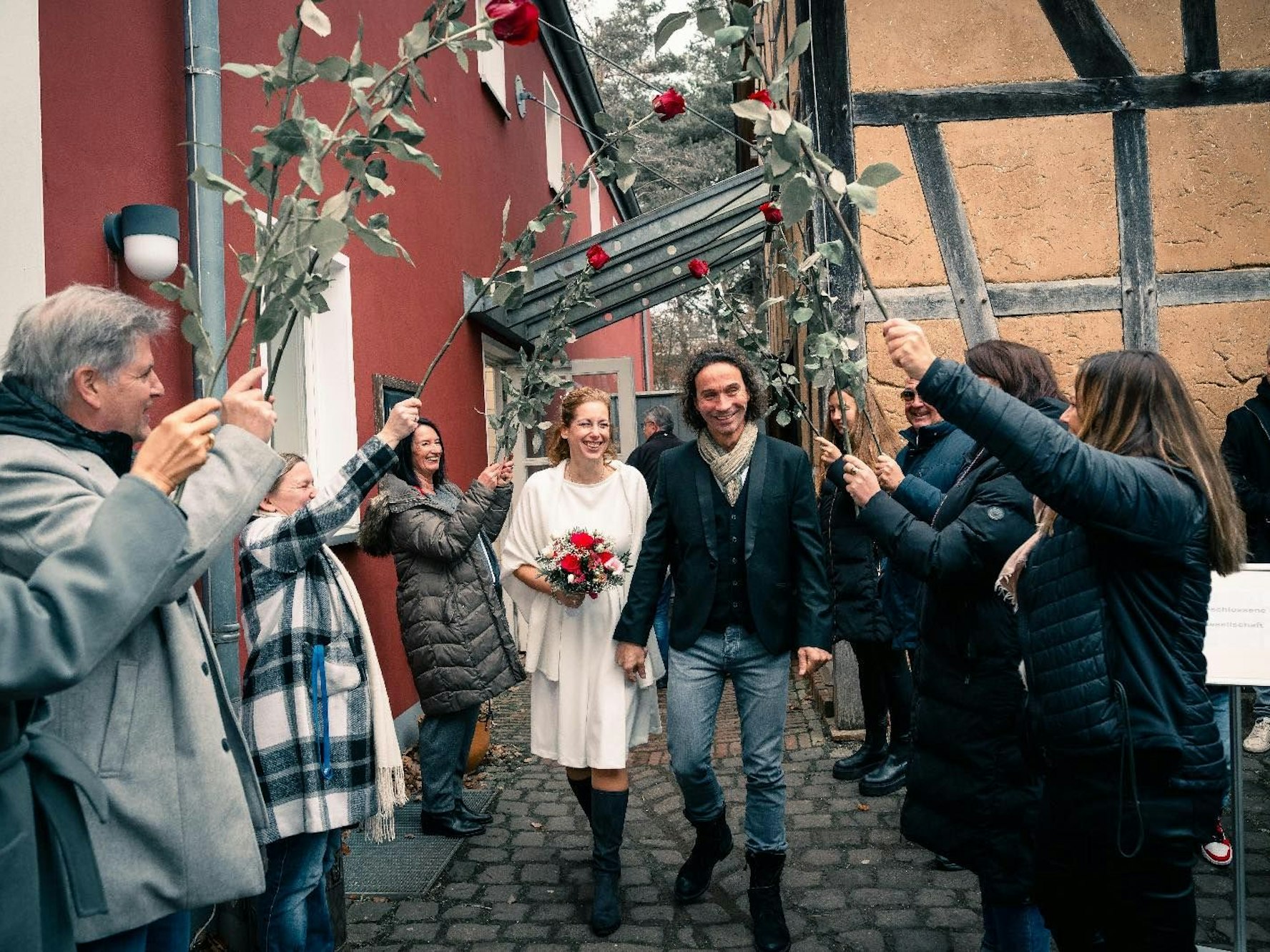 Anja und Stephan Brings gehen nach ihrer Hochzeit durch ein Spalier.