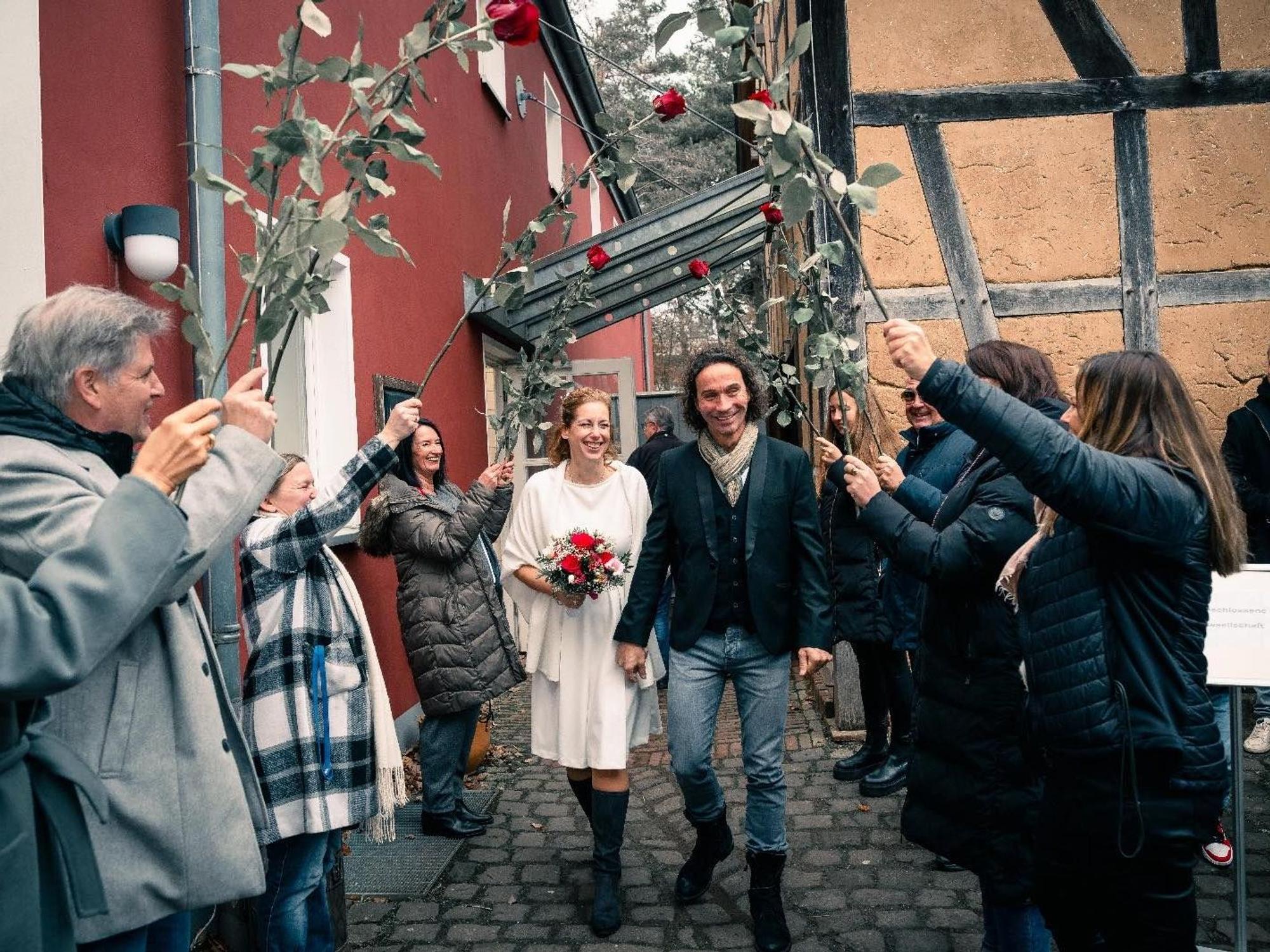 Anja und Stephan Brings gehen nach ihrer Hochzeit durch ein Spalier.