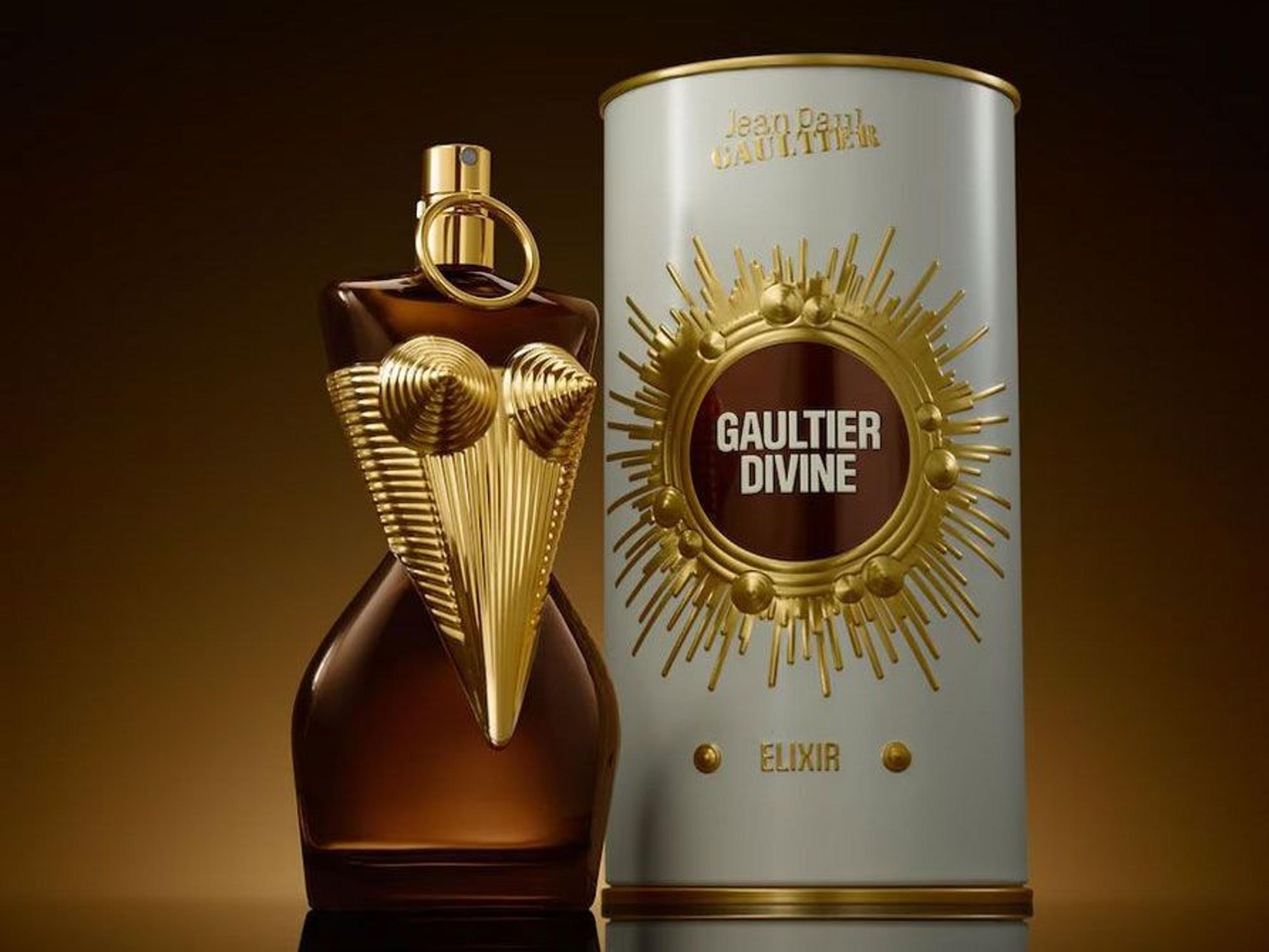 Ein Parfumflakon in Form eines Bustiers steht neben einer Dose mit der Aufschrift Jean Paul Gaultier Divine Elixir.