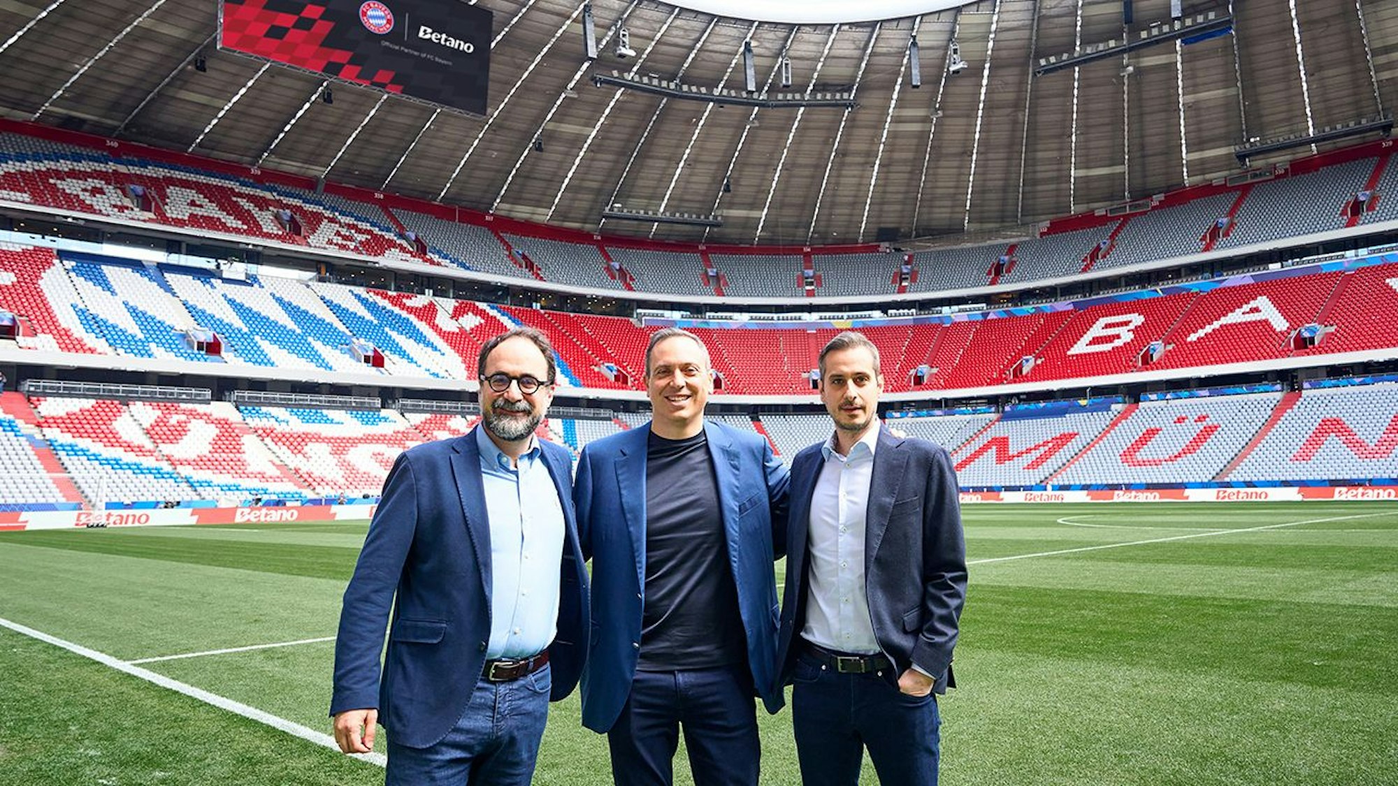 Julio Iglesias Hernando (CCO), George Daskalakis (CEO) und Christos Tzalavras (CPO) in einem Fußballstadion.