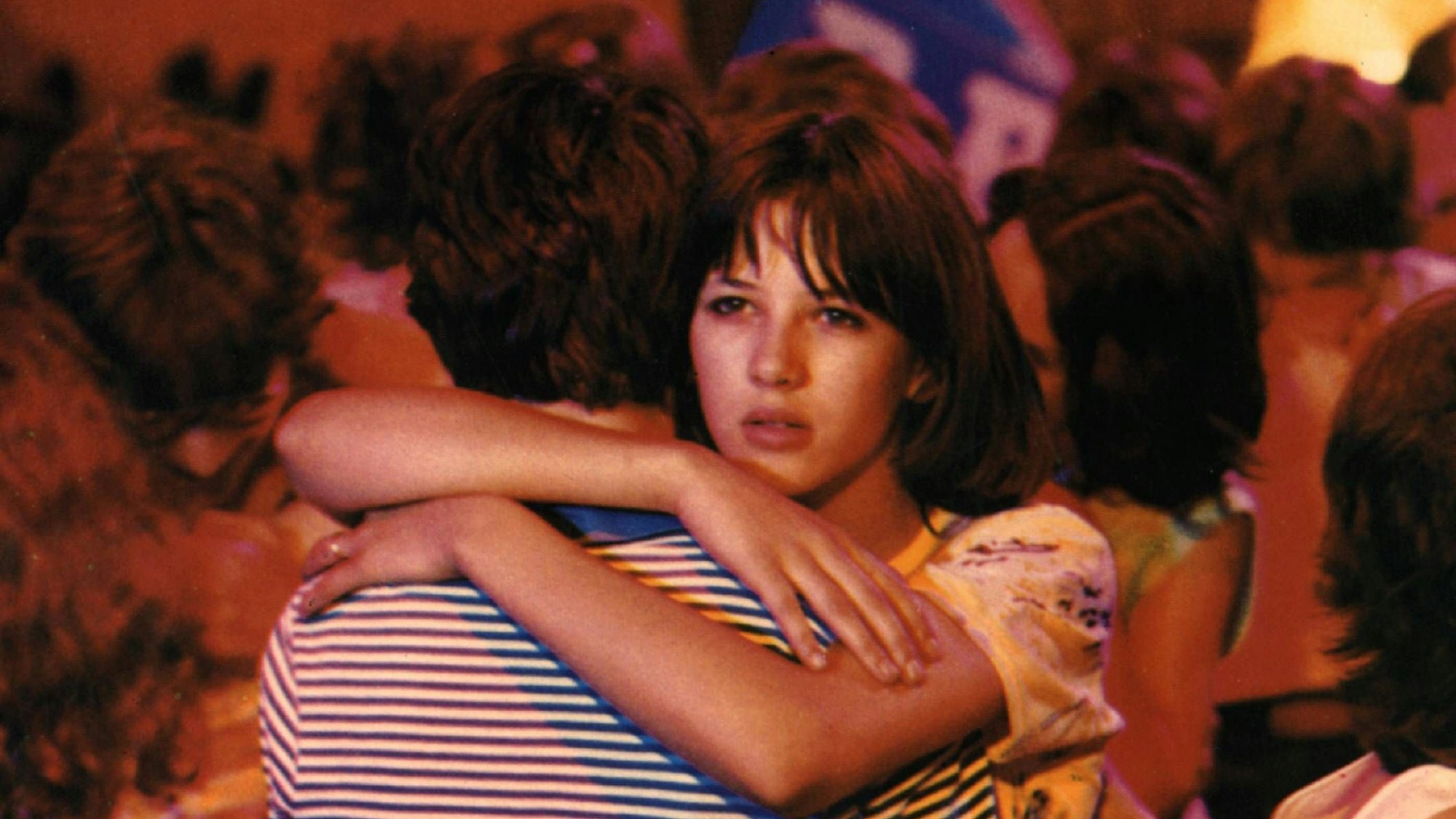 Ein junges Pärchen tanzt engumschlungen, das Mädchen schaut sehnsüchtig über die Schulter des Jungen.