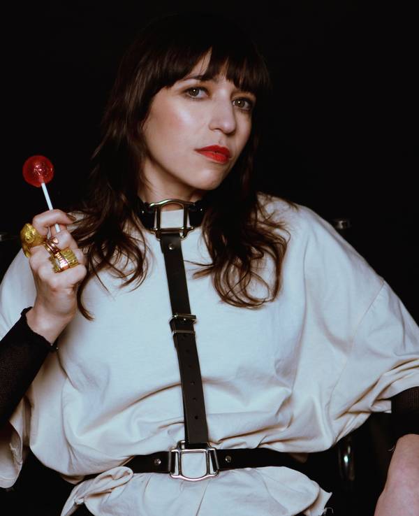 Paulita Pappel blickt in die Kamera und hält einen Lolli in der Hand.