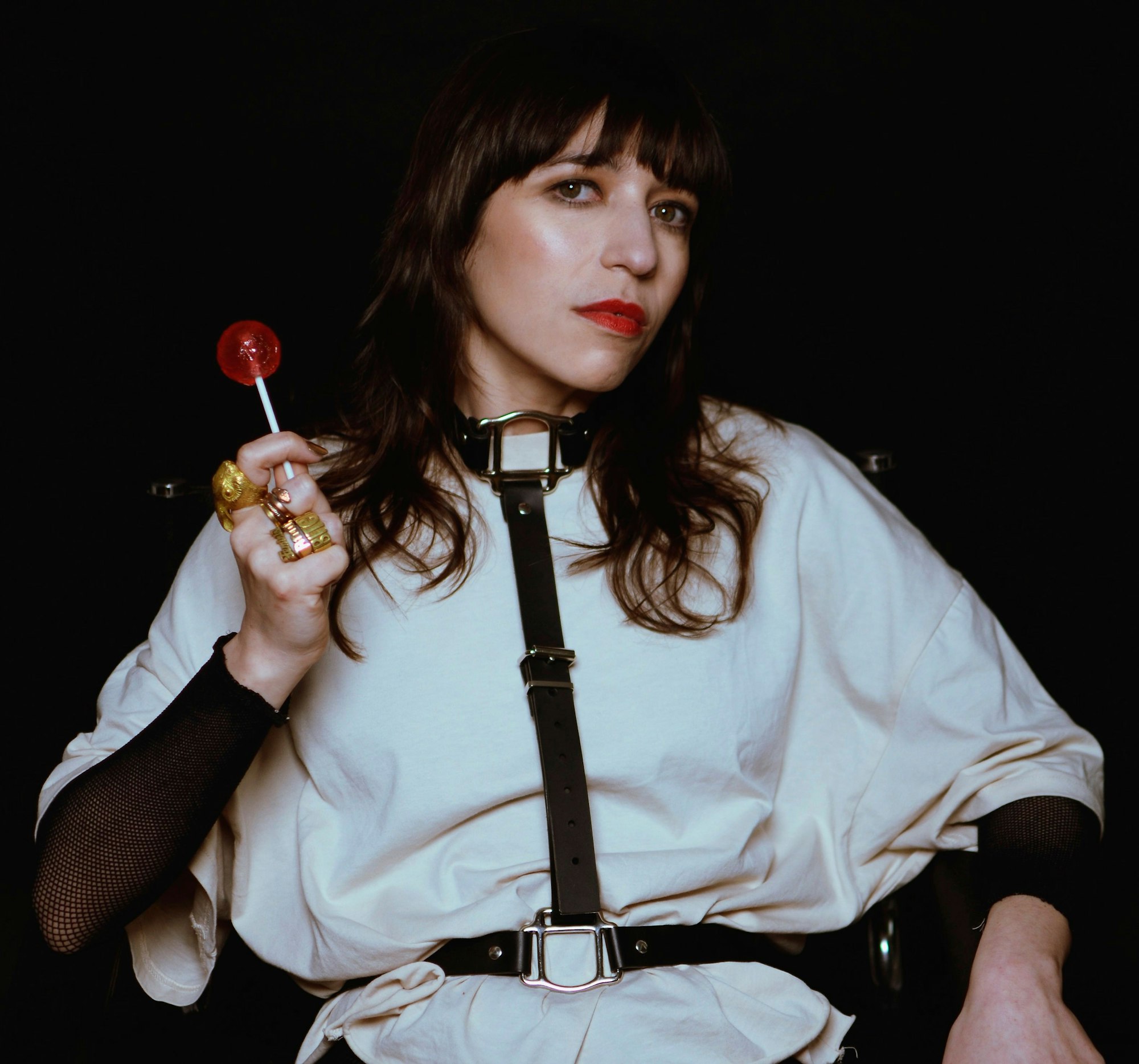 Paulita Pappel blickt in die Kamera und hält einen Lolli in der Hand.