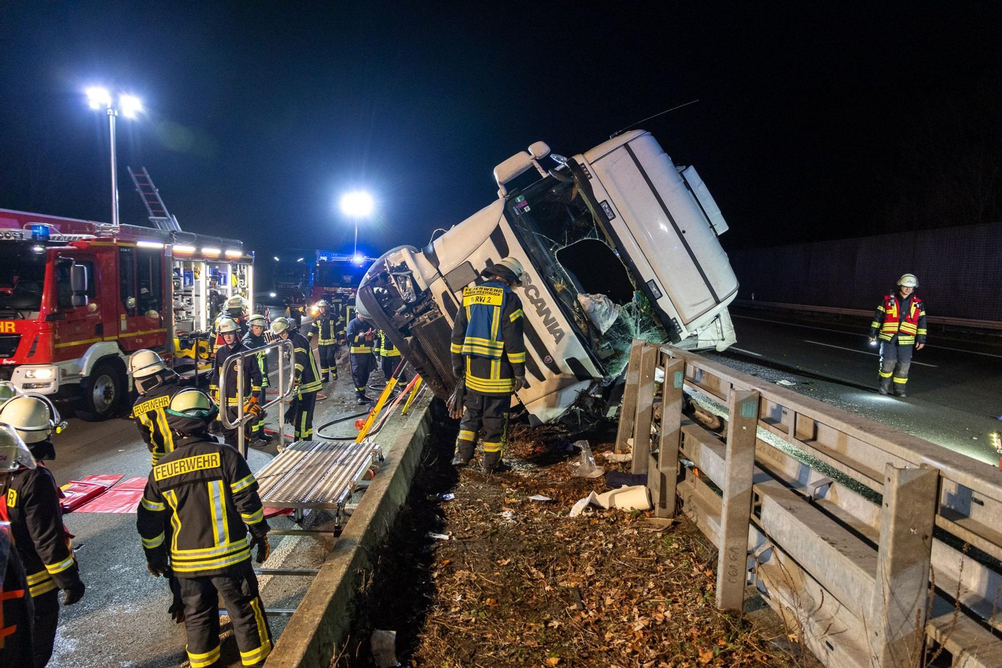 Rettungskräfte sichern die Unfallstelle um das Lkw-Wrack auf dem Mittelstreifen. Auf der A2 zwischen Veltheim und Bad Eilsen ist ein Lkw umgekippt. Laut Polizei schwebt der Fahrer in Lebensgefahr.