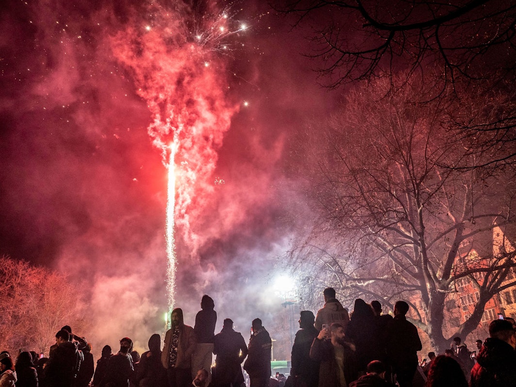 Feiernde lassen Silvesterraketen im Bereich der Kölner Altstadt in den Himmel steigen.