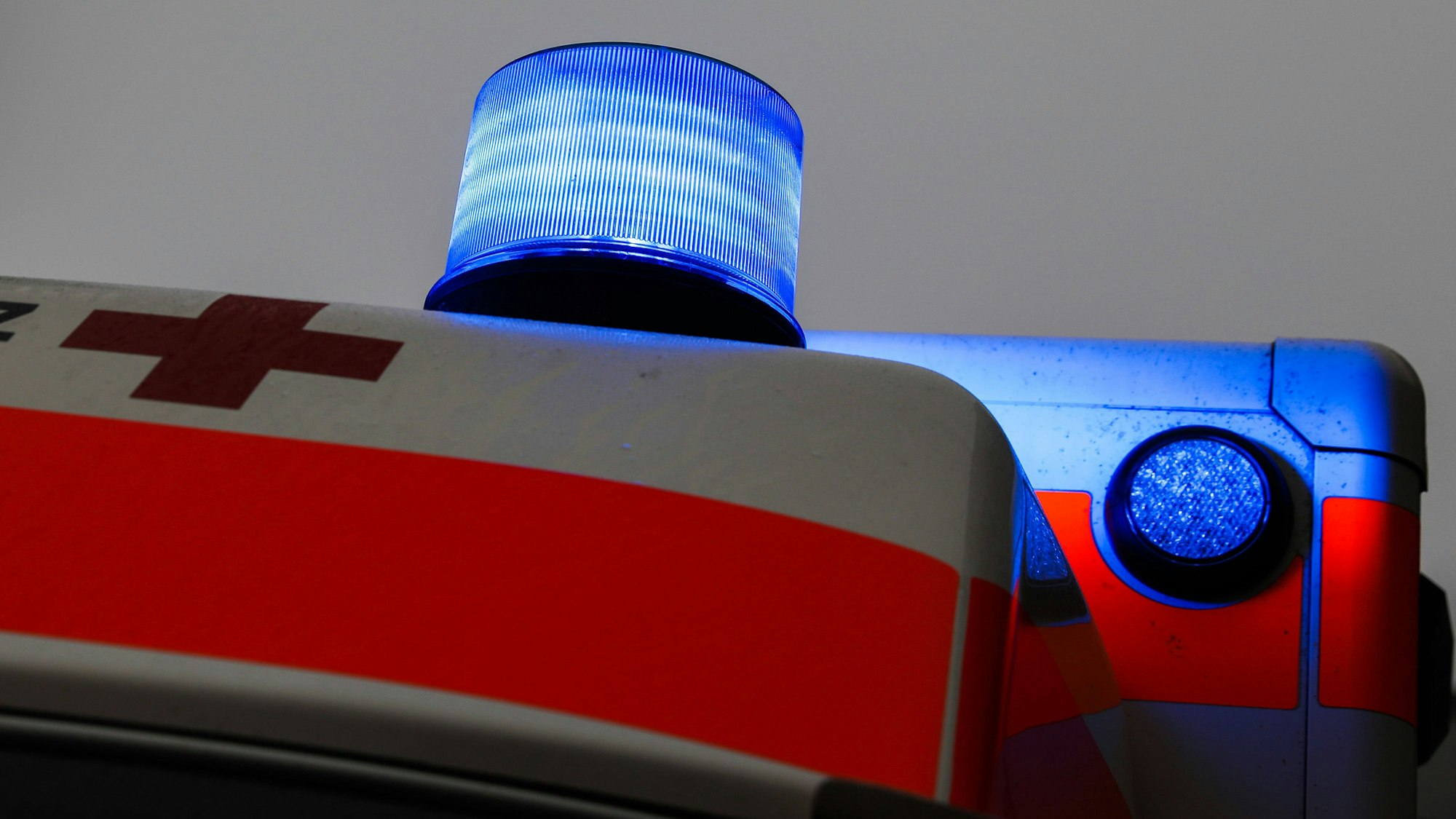 Blaulicht auf dem Dach eines Rettungswagens mit rotem Kreuz