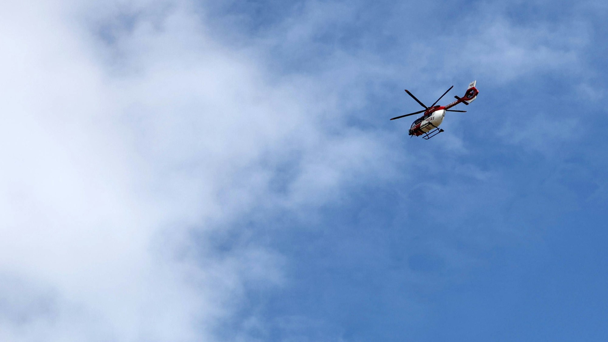 Rettungshubschrauber fliegt am blauen Himmel