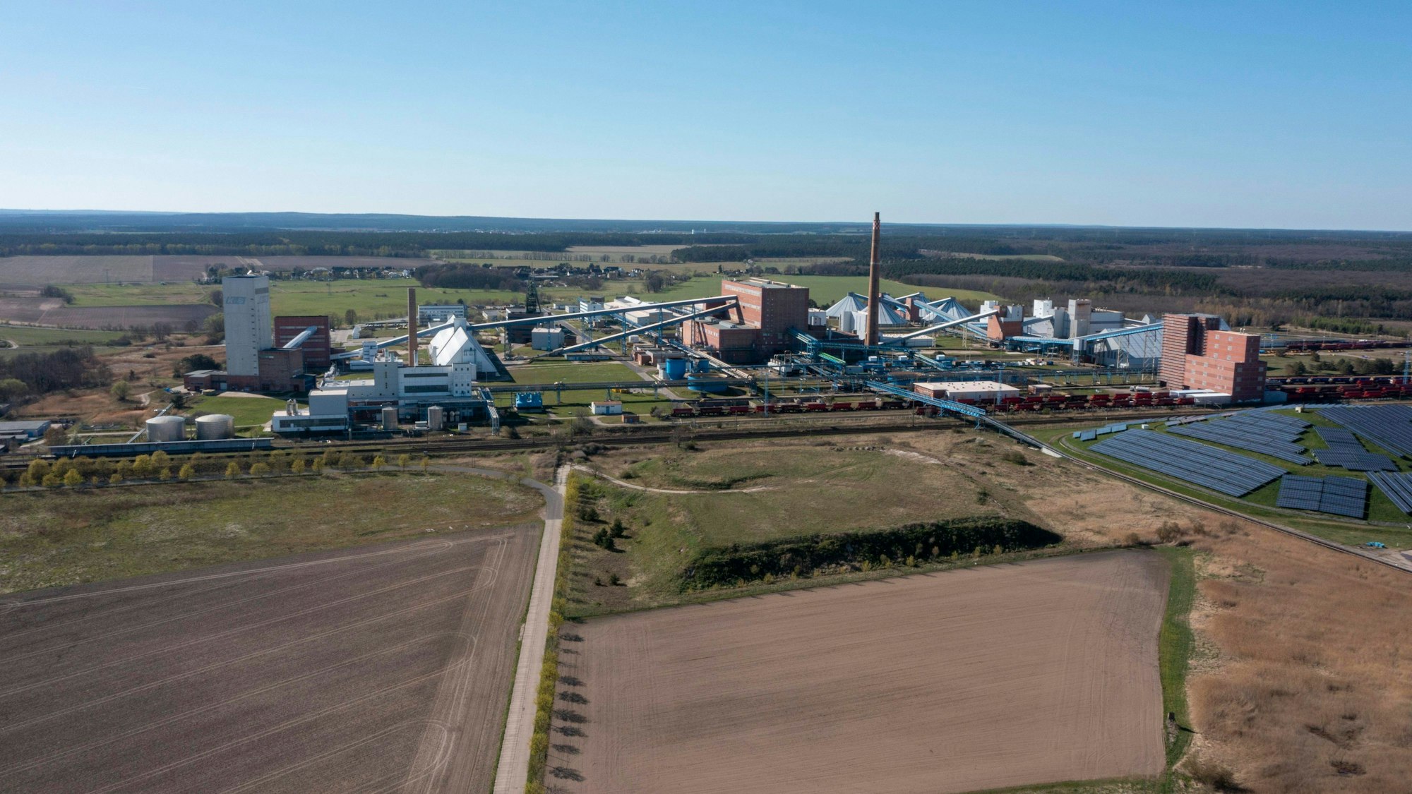 Luftaufnahme eines Industriegebiets mit Feldern und Solarpark