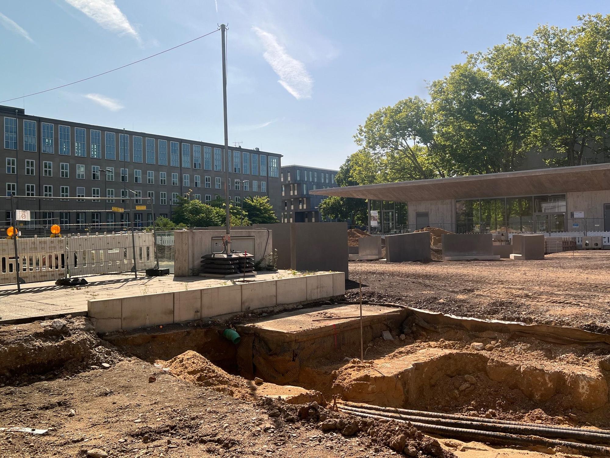 Auf einem Platz ist das Erdreich freigelegt und eine Grube gegraben worden.
