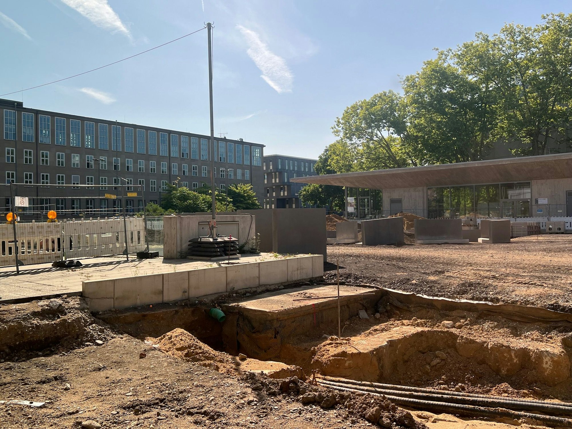 Auf einem Platz ist das Erdreich freigelegt und eine Grube gegraben worden.