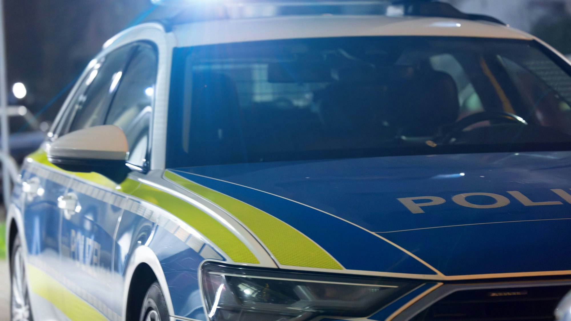 Polizeifahrzeug mit leuchtendem Blaulicht bei Nacht