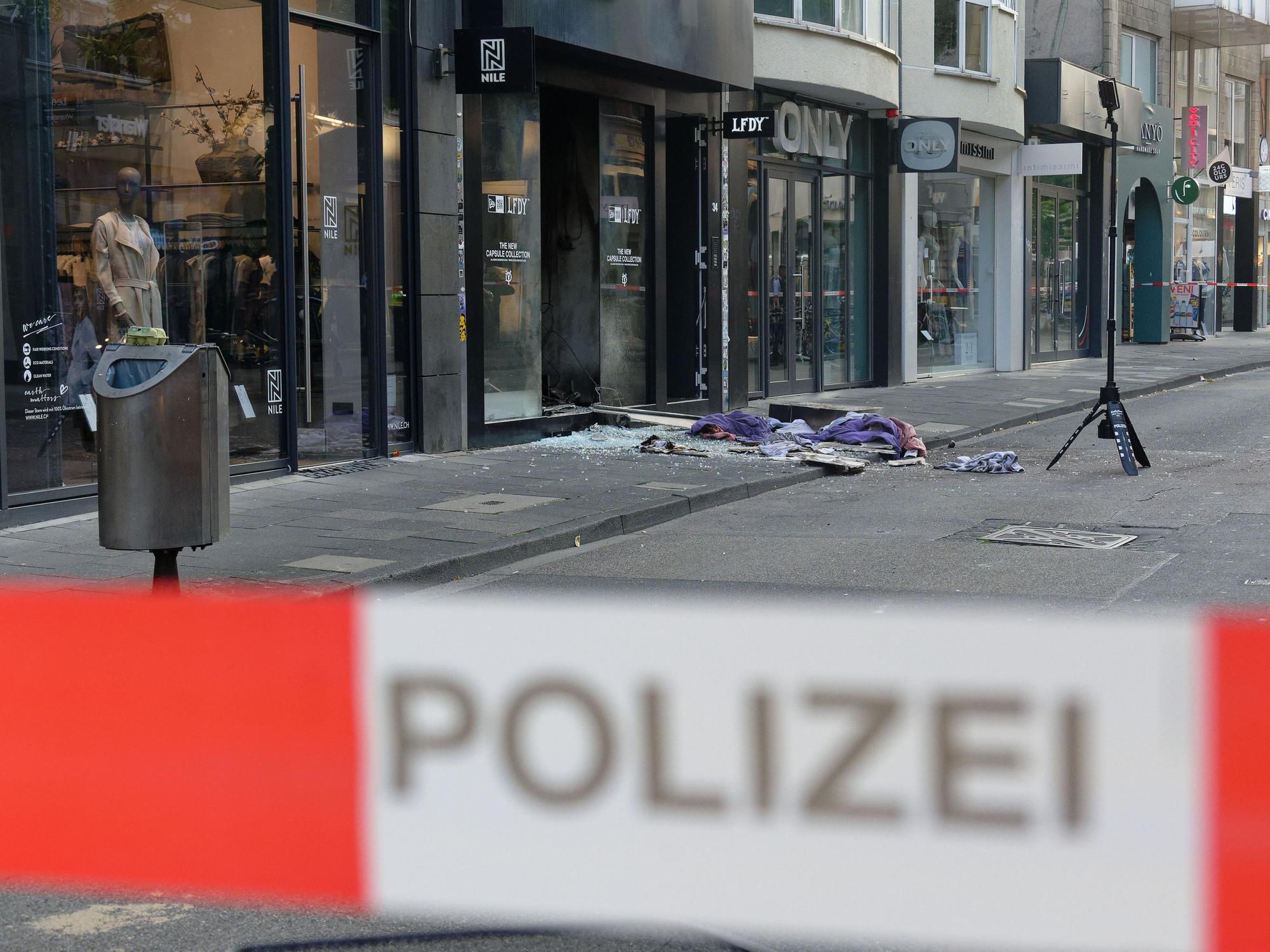 Scherben und Kleidungstücke liegen vor einem Geschäft in der Ehrenstraße in Köln.