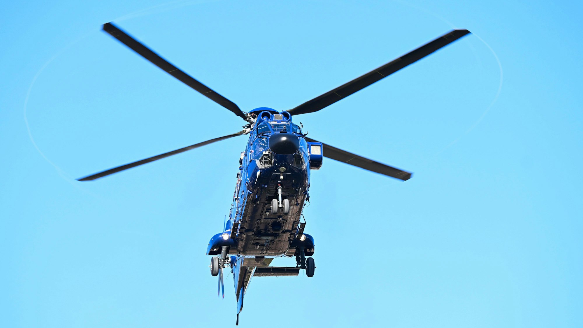 Blauer Hubschrauber am hellblauen Himmel