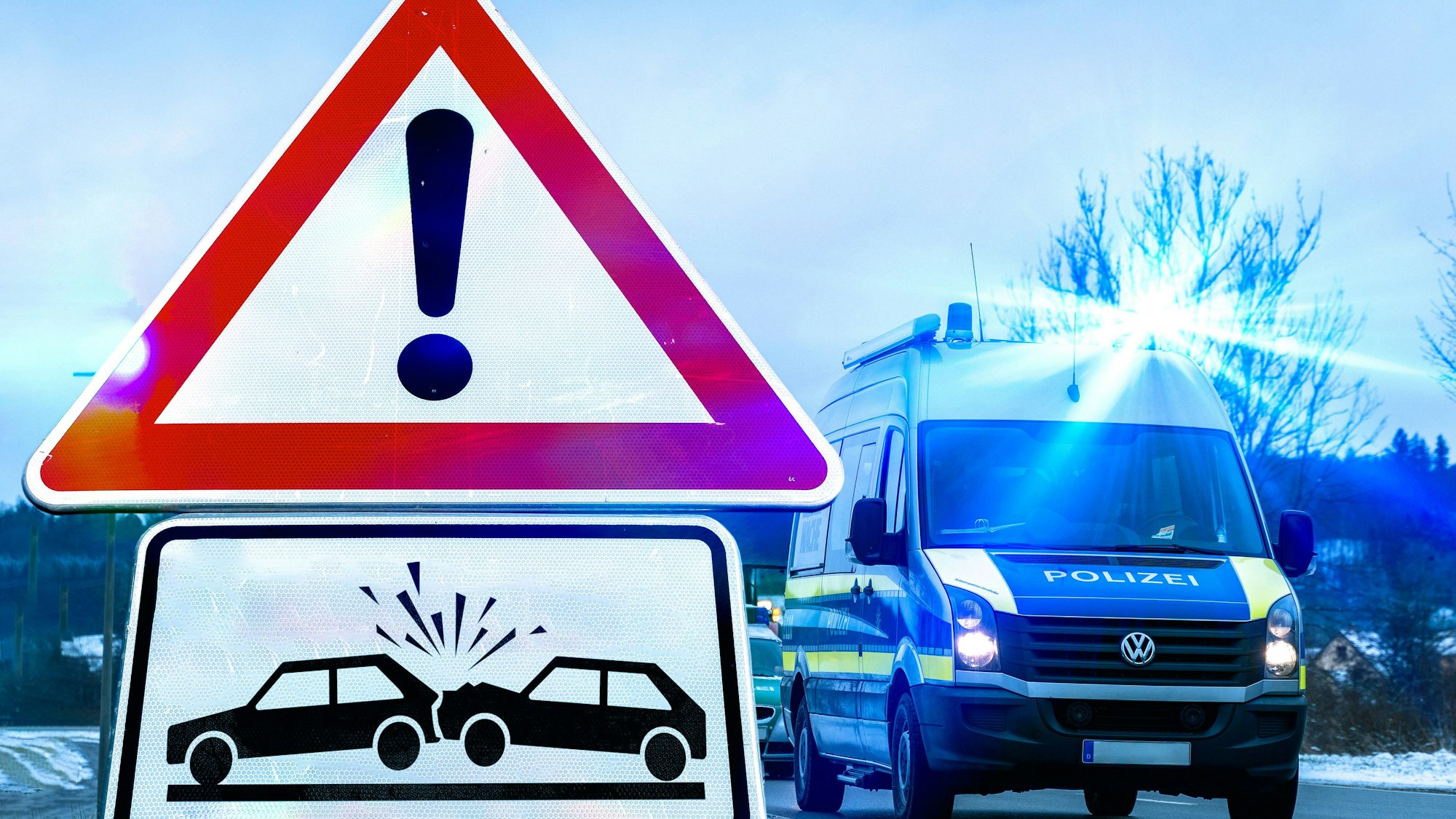 Polizeifahrzeug mit Blaulicht und Unfall Warnschild