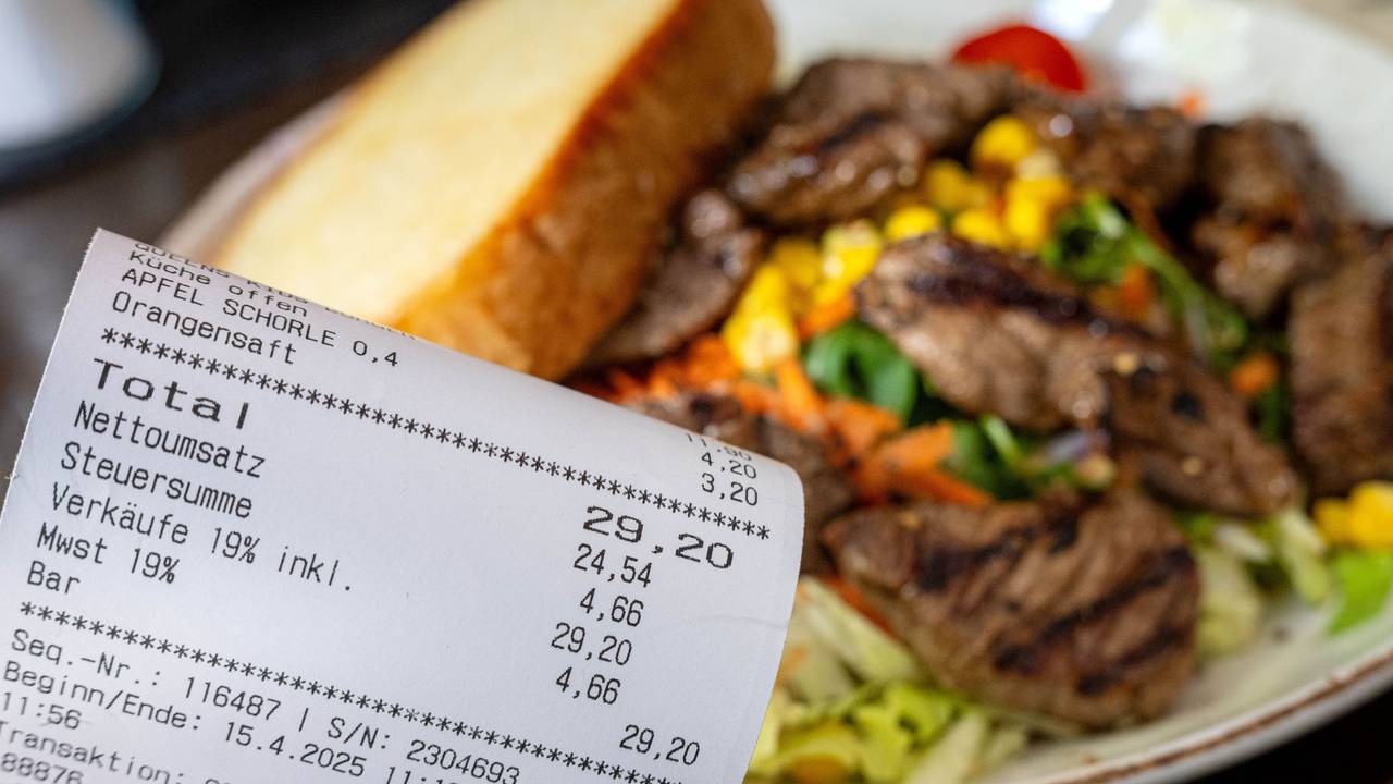 Eine Rechnung mit Mehrwertsteuer neben einem vollen Teller in einem Restaurant. Für die Gastronomie gibt es gute Nachrichten ausd em Bundesrat.