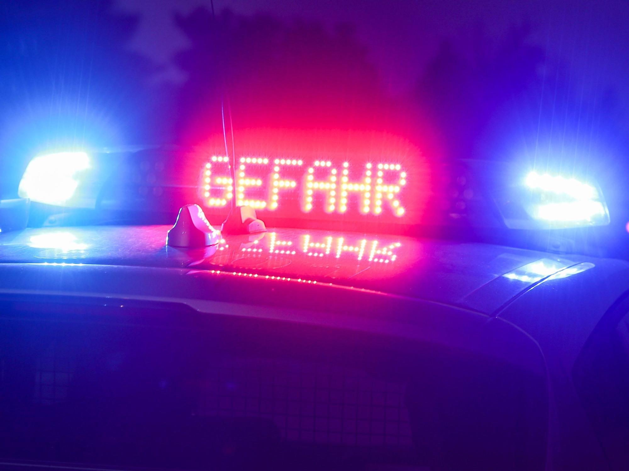 Ein Polizeifahrzeug mit Blaulicht und der Anzeige „Gefahr“.