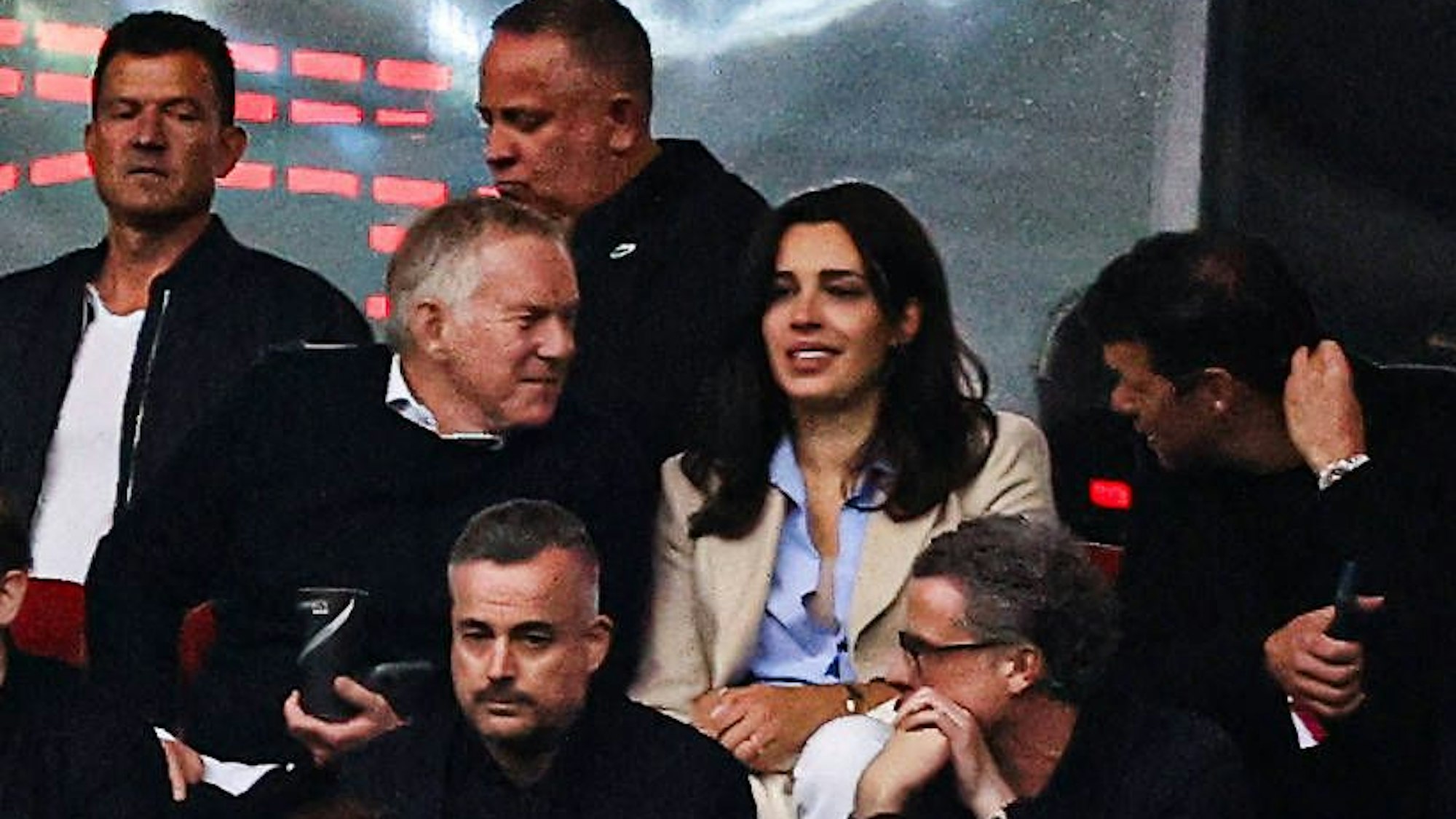 Blick auf die Tribüne eines Fußballstadions, auf der sich mehrere Menschen unterhalten.