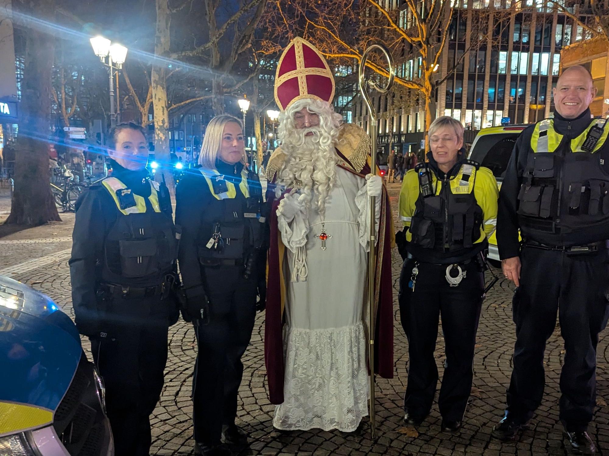 Vier Polizistinnen und Polizisten posieren für ein Foto mit dem Darsteller des heiligen Nikolaus'