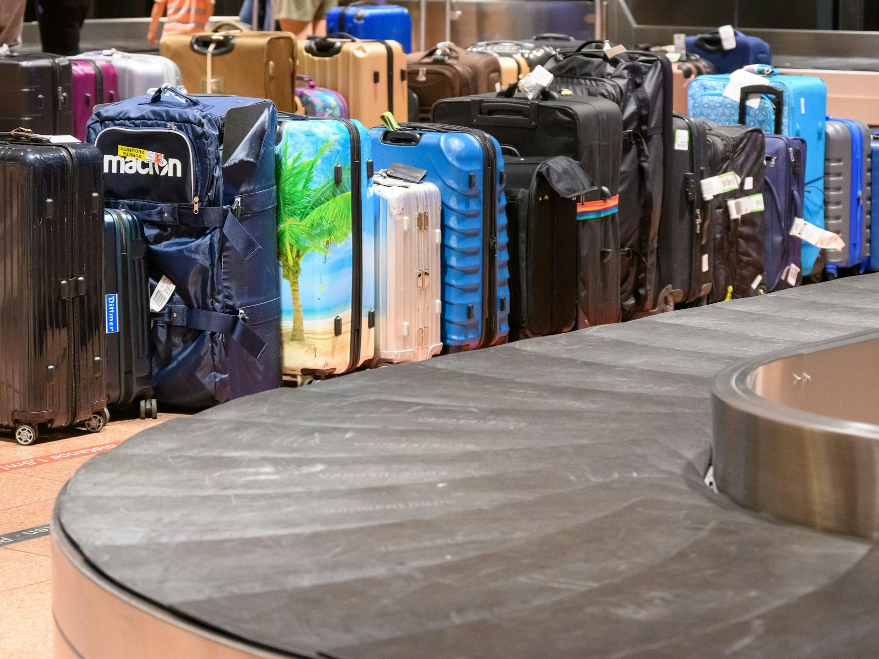 Koffer stehen neben einem Gepäckband am Flughafen. Nicht selten finden Koffer erst nach Tagen ihre Besitzer. Ein Kölner Paar vermisst seit Tagen sein Gepäck. (Symbolfoto)