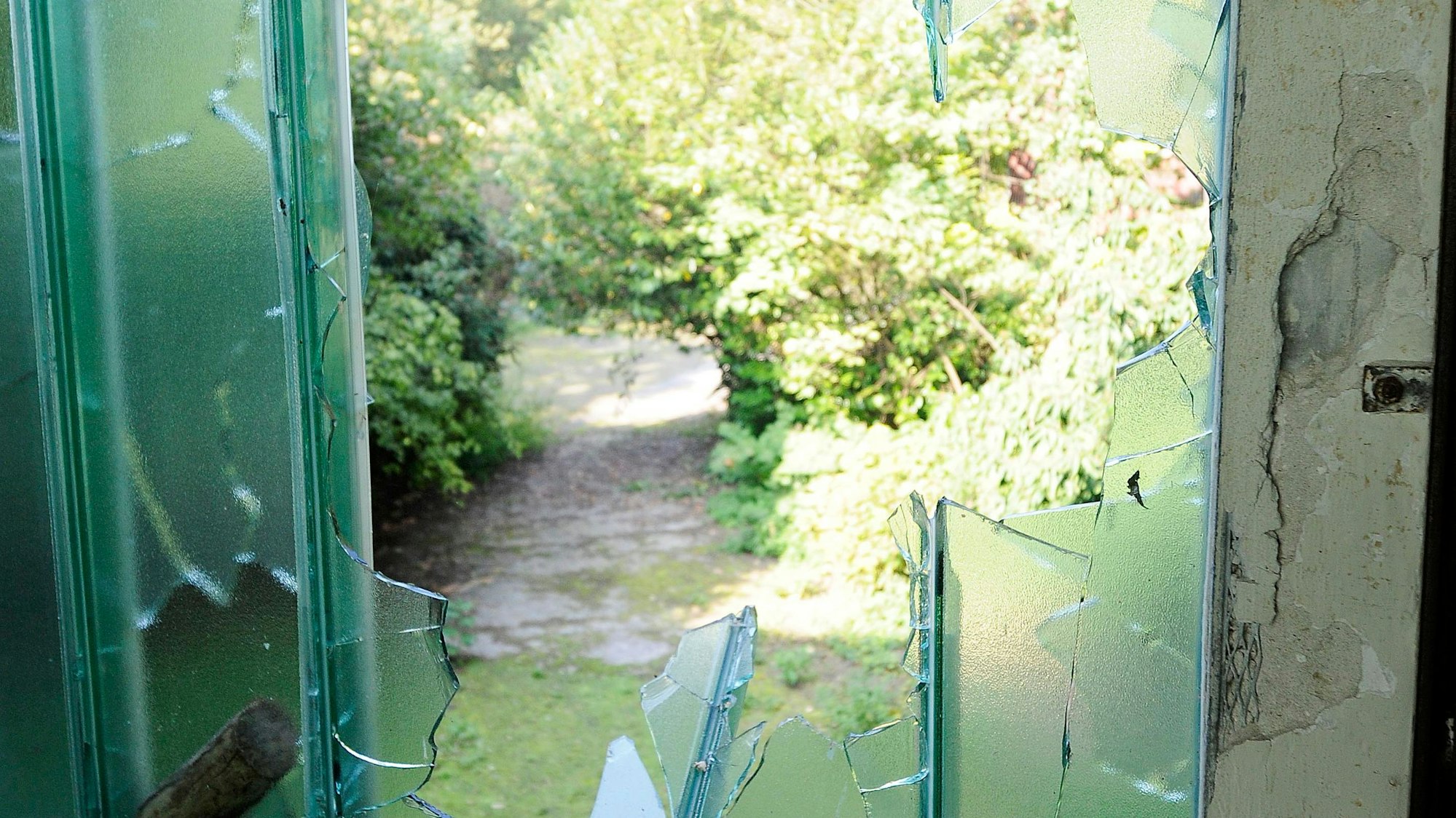 Zerbrochenes Fenster mit Glassplittern in verlassener Turnhalle