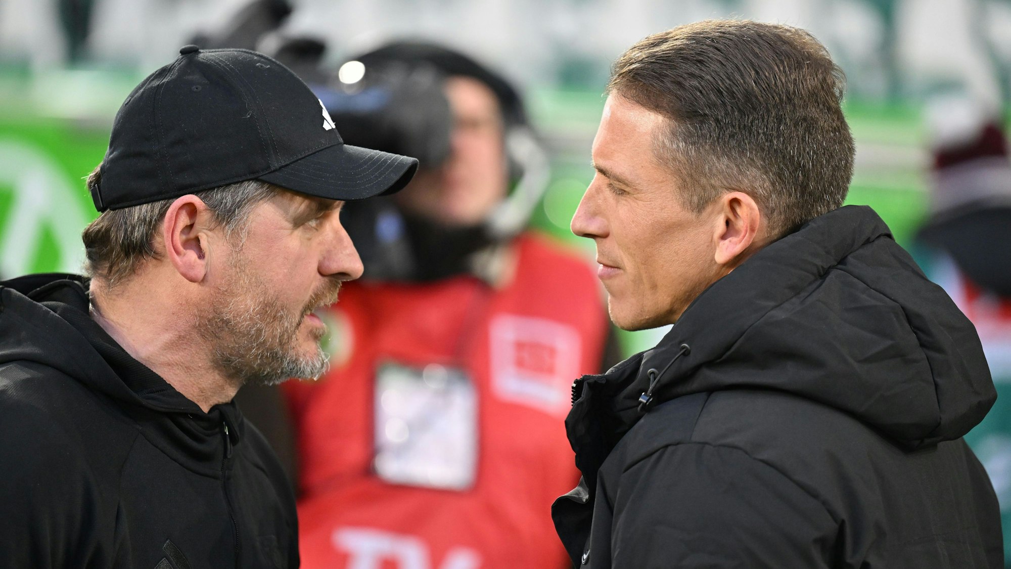Trainer Steffen Baumgart (l.) und Trainer Daniel Bauer sprechen vor dem Spiel miteinander.