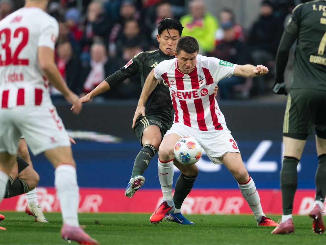 Dominique Heintz (r., 1. FC Köln) und Woo-yeong Jeong (1. FC Union Berlin) kämpfen um den Ball am 20. Dezember 2025.