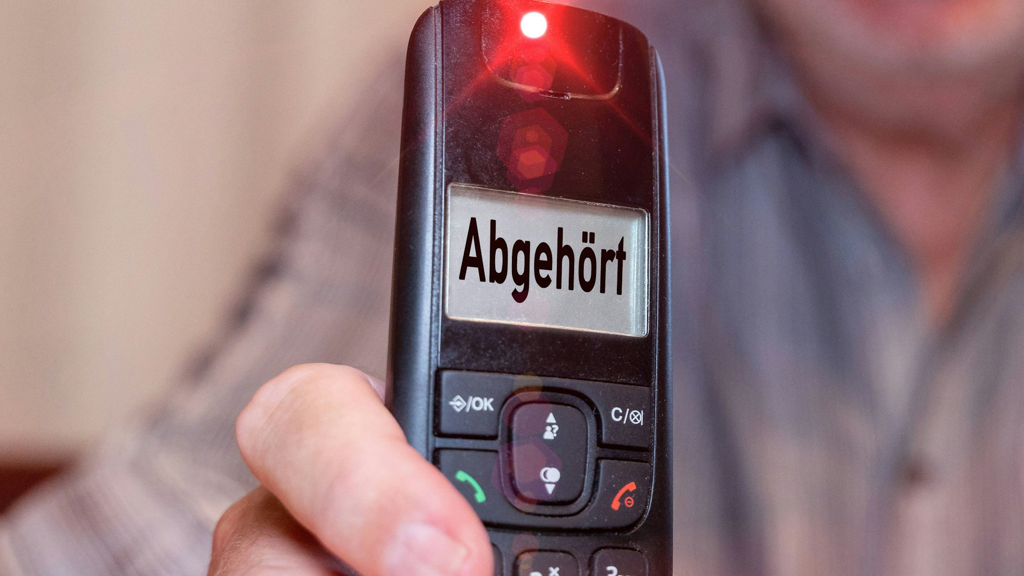 Hand hält Telefon mit der Anzeige Abgehört