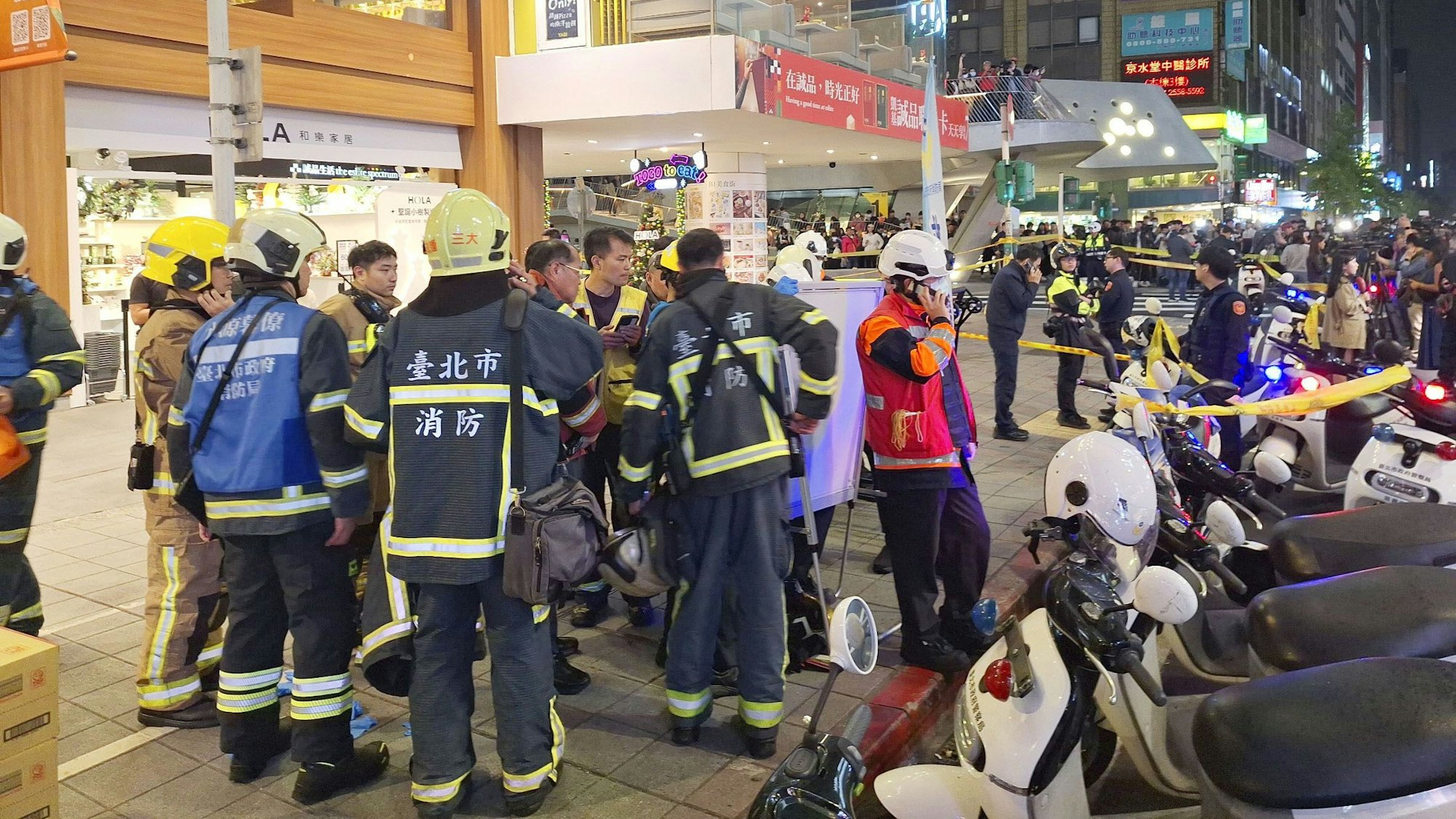 Rettungskräfte und Polizisten sind an einem Tatort im Geschäftsviertel von Taipeh im Einsatz.