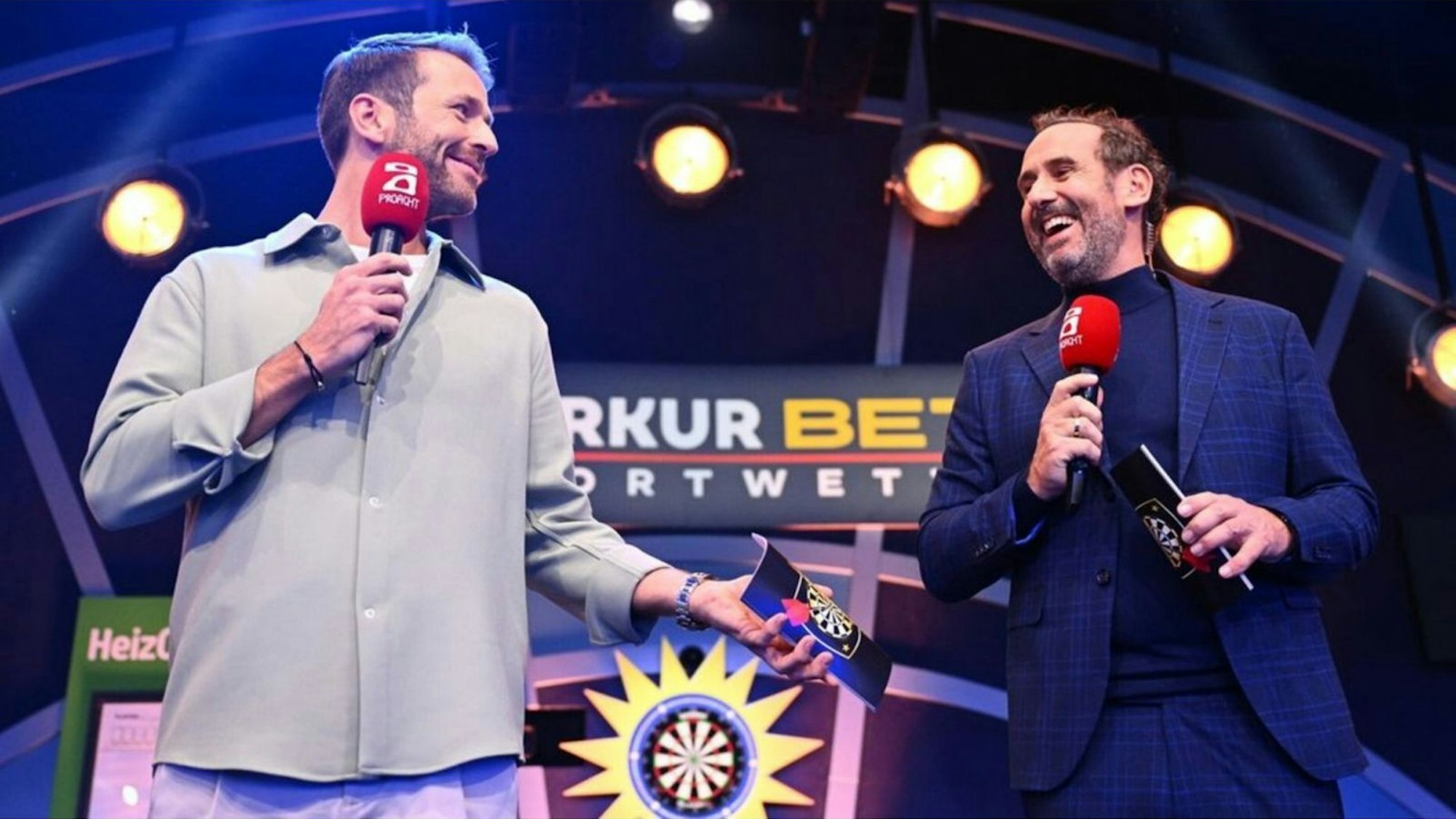 Eingespieltes Team: Christian Düren (links) und Elmar Paulke führen durch „Die Promi-Darts-WM“ bei ProSieben. (Bild: ProSieben/Willi Weber)