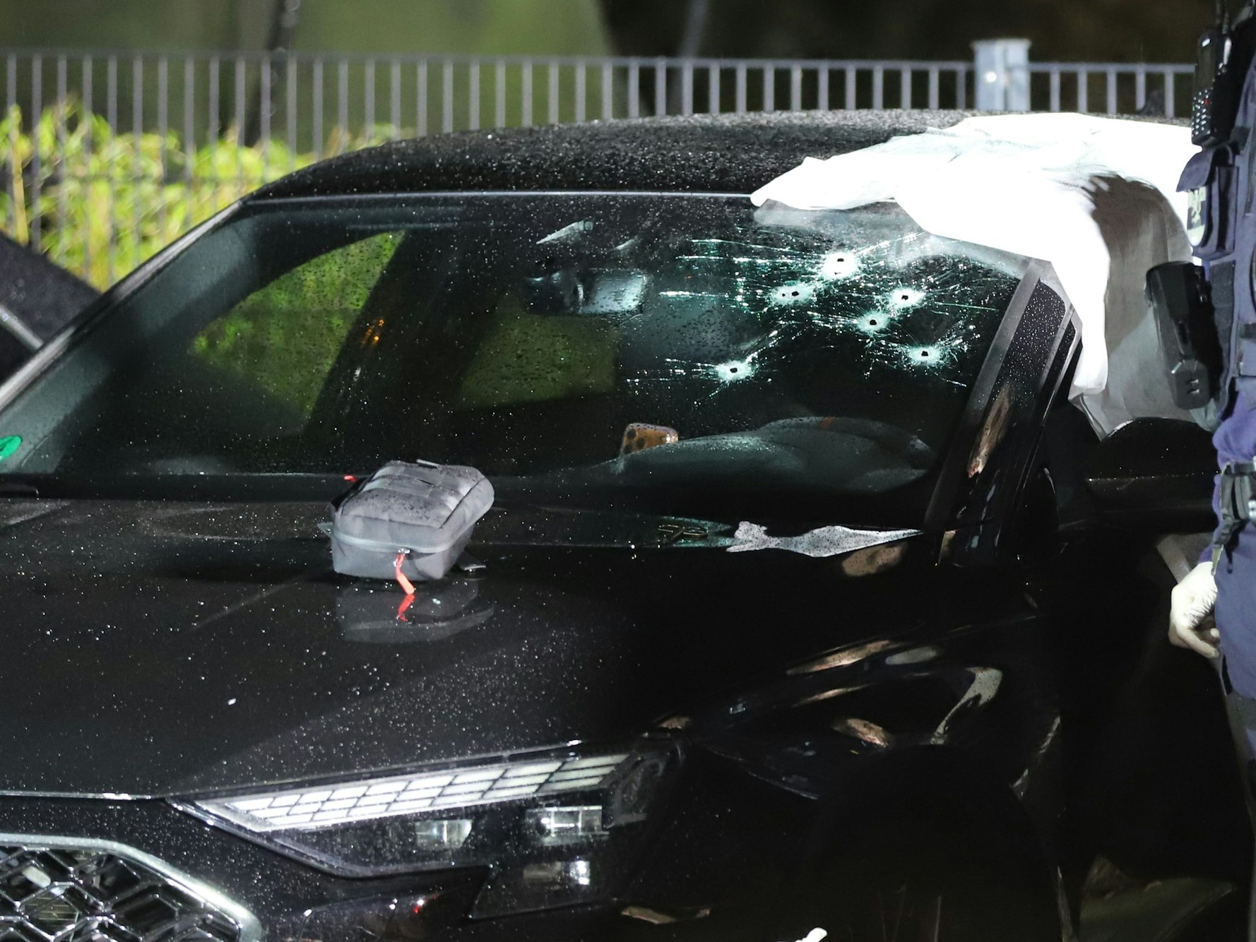 In der Windschutzscheibe eines Pkw sind mehrere Einschusslöcher.