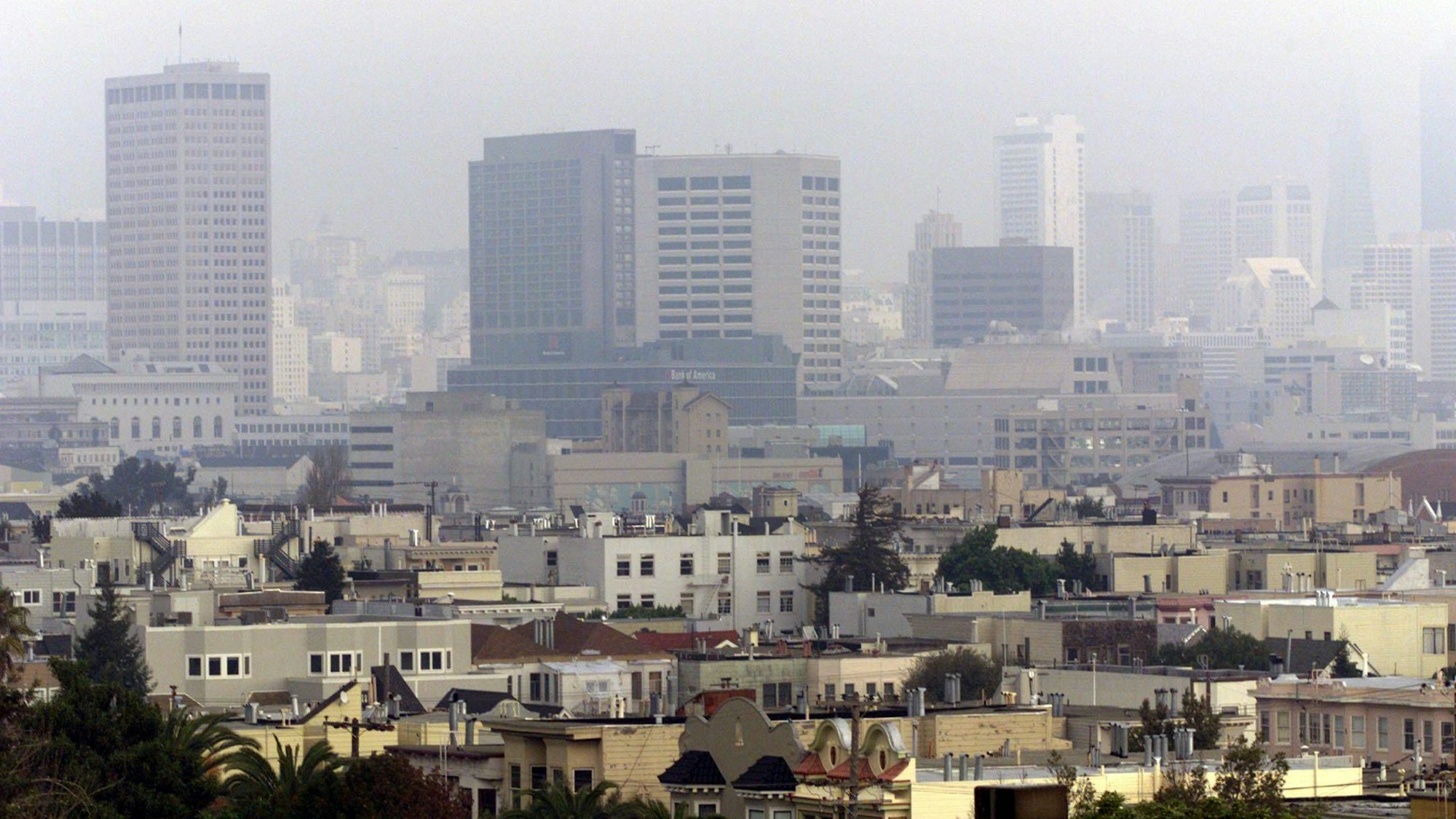 Dunstiges Stadtpanorama mit Hochhäusern und vielen Dächern