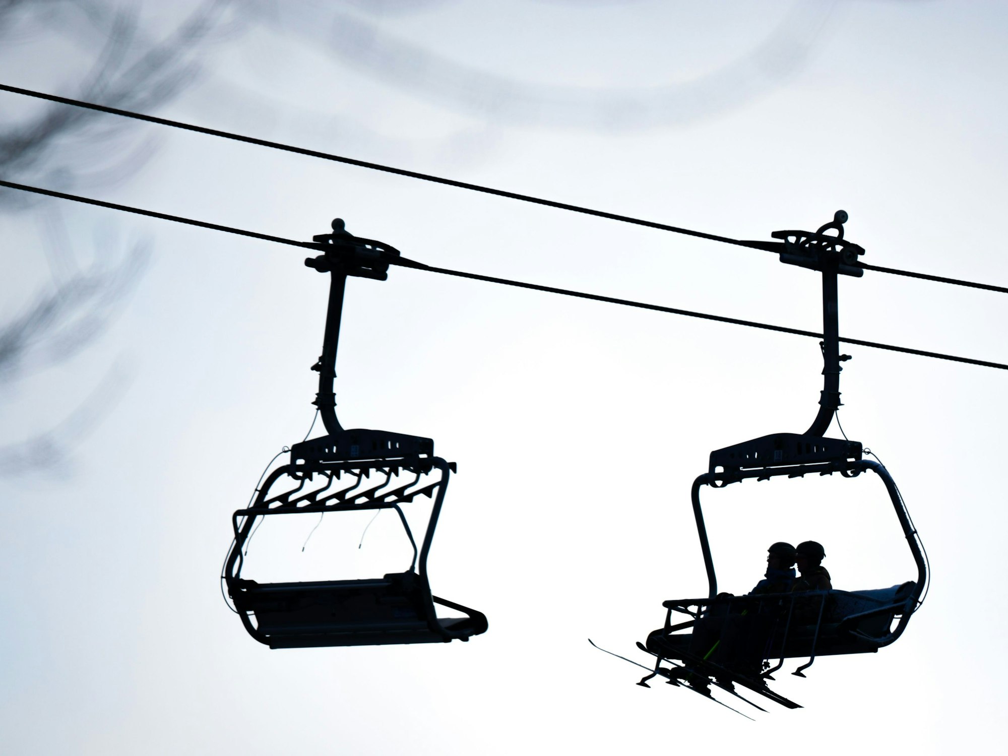 Skifahrer sitzen in einem Sessellift.