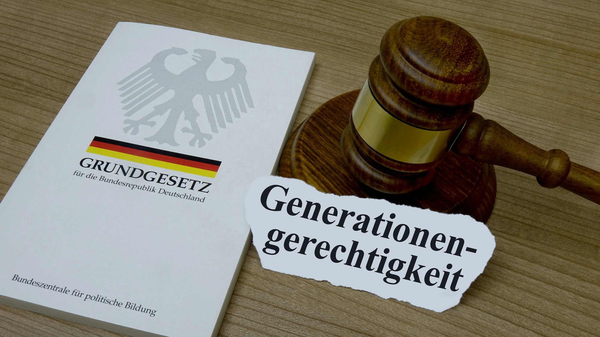 Grundgesetz mit Richterhammer und Generationengerechtigkeit auf Holztisch