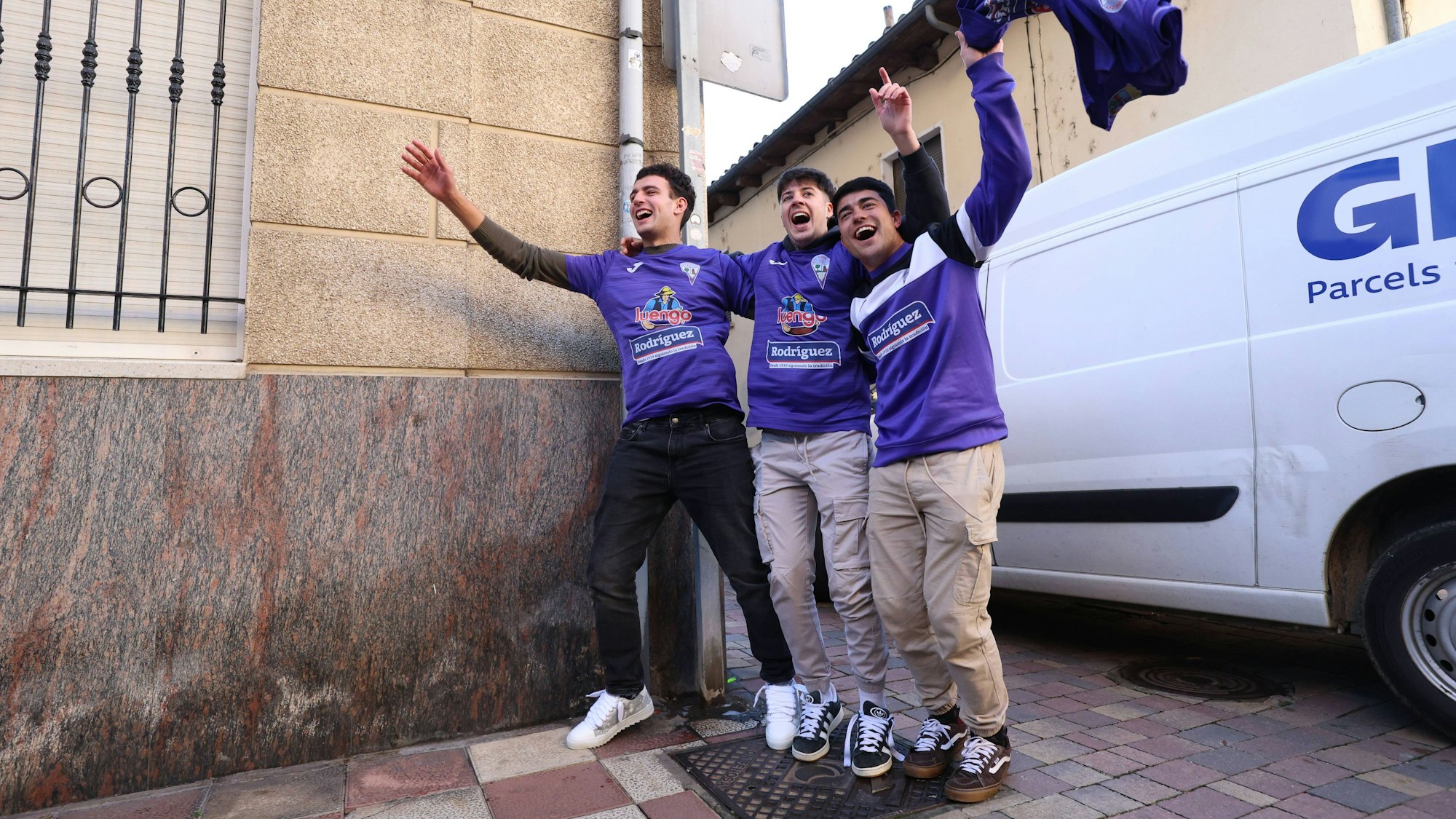 Lotto-Gewinner im Trikot des La Bañeza Fútbol Club jubeln auf der Straße.
