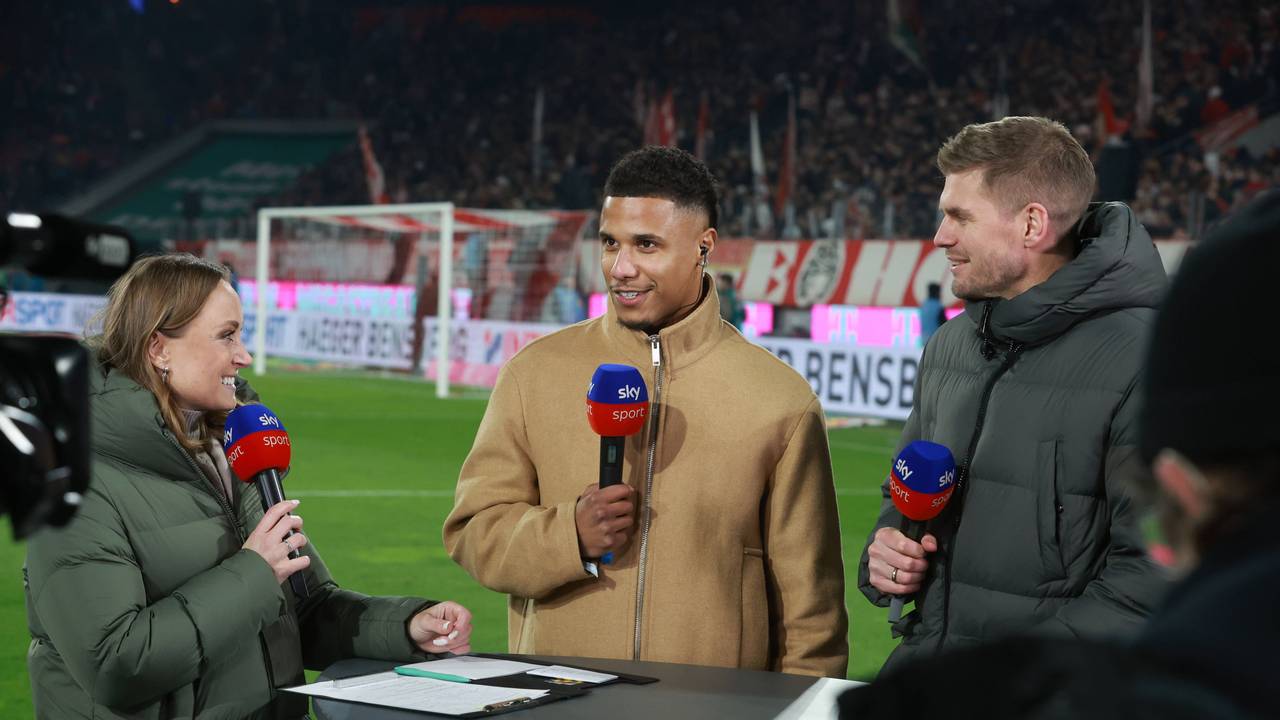Ismail Jakobs steht bei Sky am Tisch und spricht in ein Mikrofon.