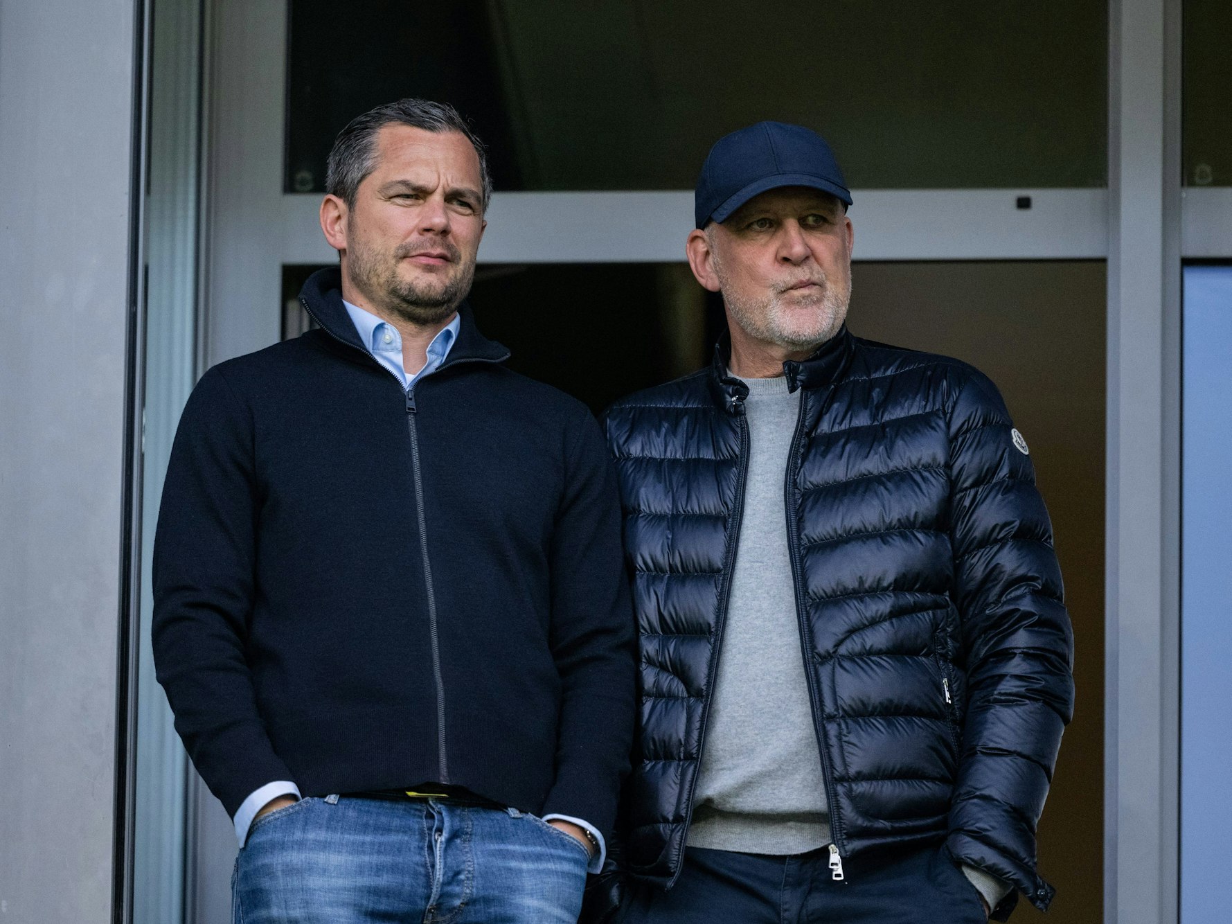 Jörg Schmadtke und Marcel Schäfer stehen auf der Tribüne nebeneinander.